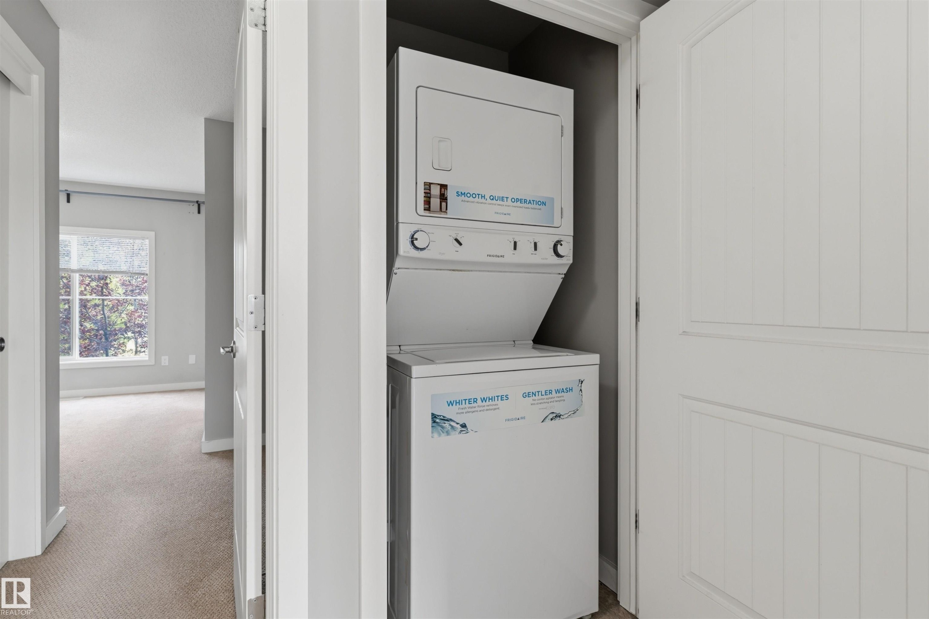 Dedicated laundry closet with stacked appliances and paneled door - #62 675 Watt Bv Sw, Edmonton, AB