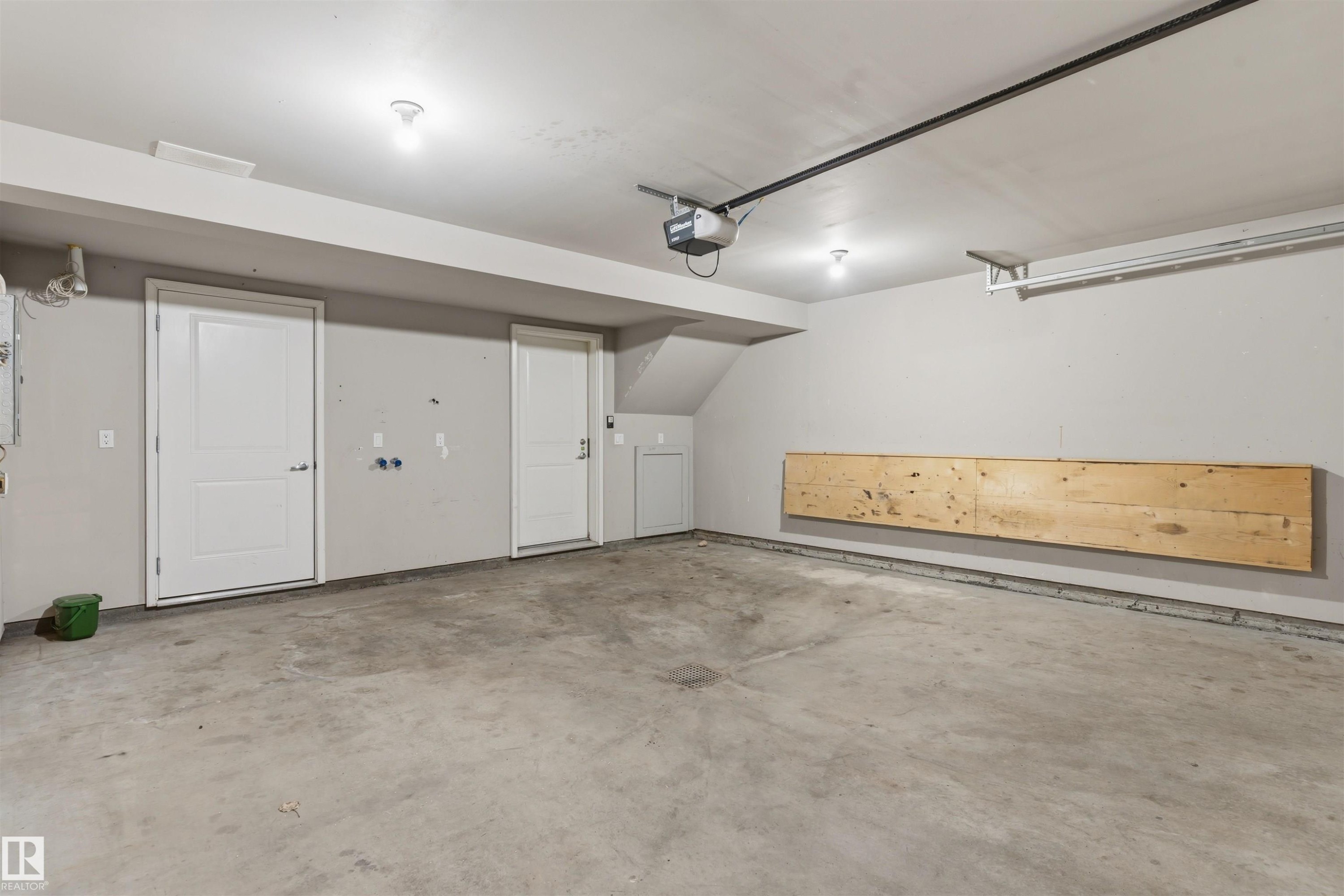 Concrete flooring, overhead lighting, two panel doors, and a built-in wood-finish shelf - #62 675 Watt Bv Sw, Edmonton, AB