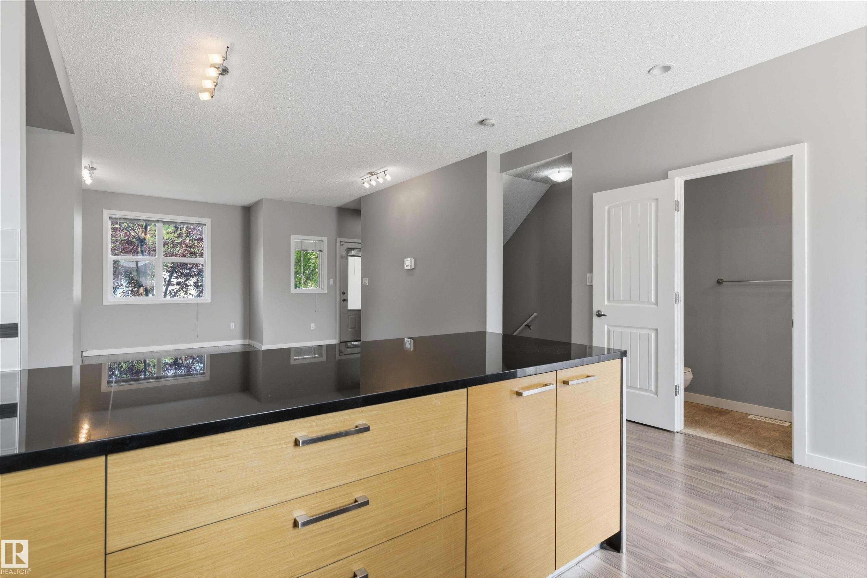 Kitchen island with wood-finish cabinetry and a dark countertop - #62 675 Watt Bv Sw, Edmonton, AB