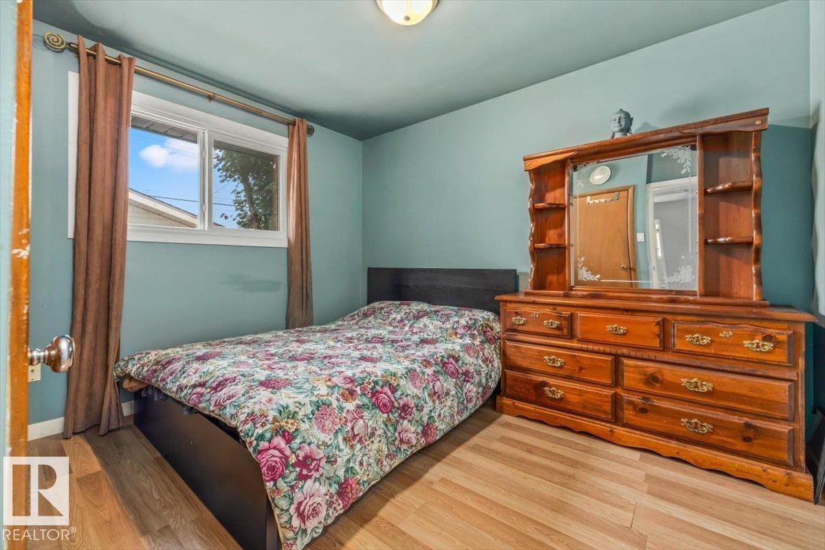 Bedroom featuring wood-finish flooring, a single window, and a ceiling-mounted light fixture - 13320 123 Street Nw, Edmonton, AB - Indoor Photo Showing Bedroom