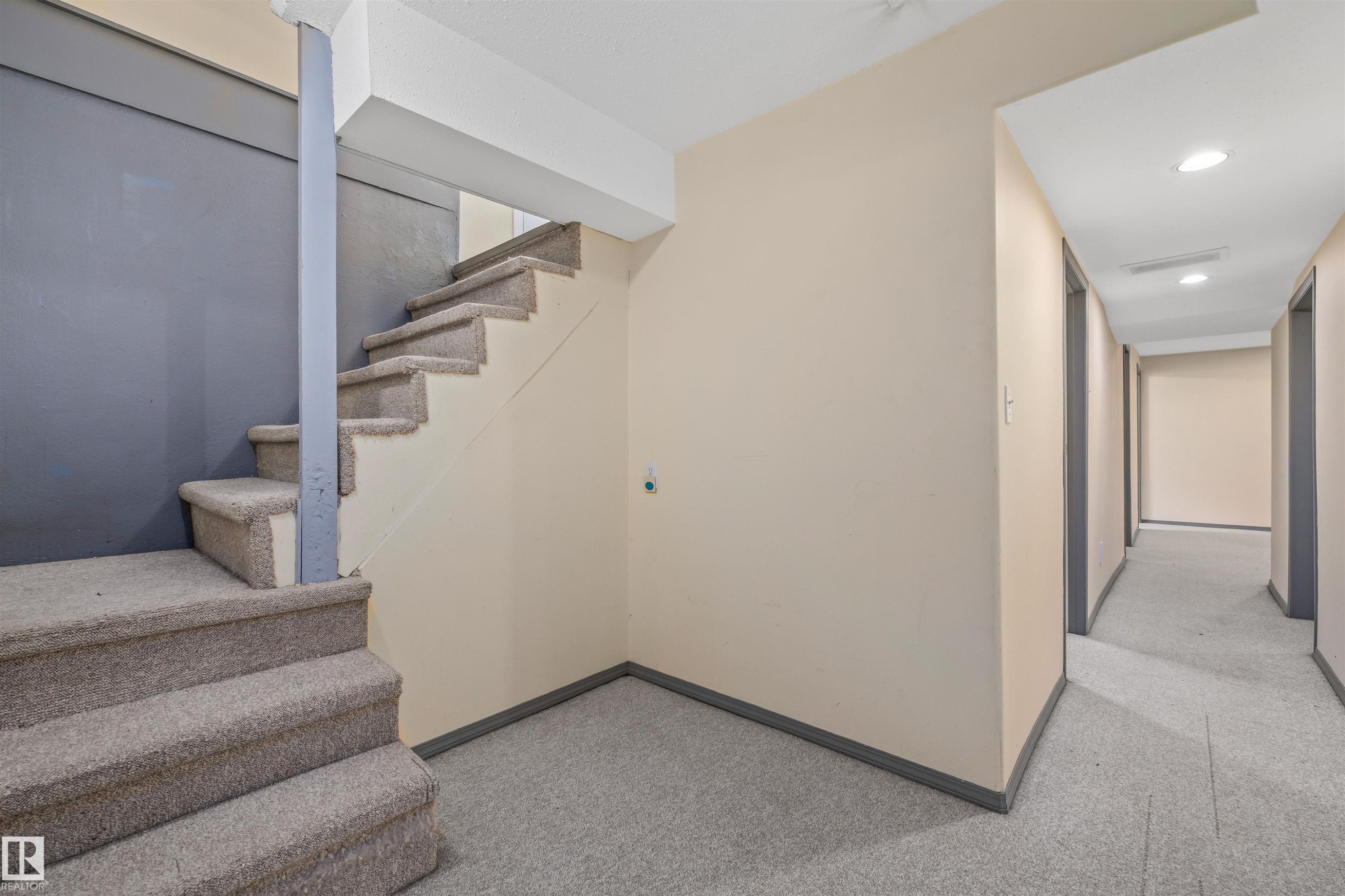 Carpeted staircase featuring a painted beam and contrasting wall colors - 13320 123 Street Nw, Edmonton, AB - Indoor Photo Showing Other Room