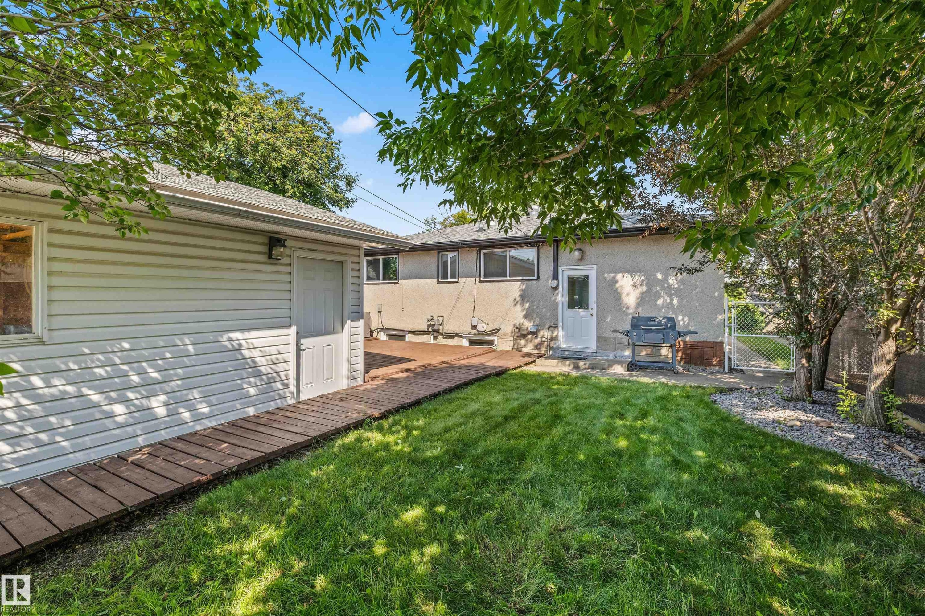 Expansive green lawn with mature trees providing partial shade - 13320 123 Street Nw, Edmonton, AB - Outdoor
