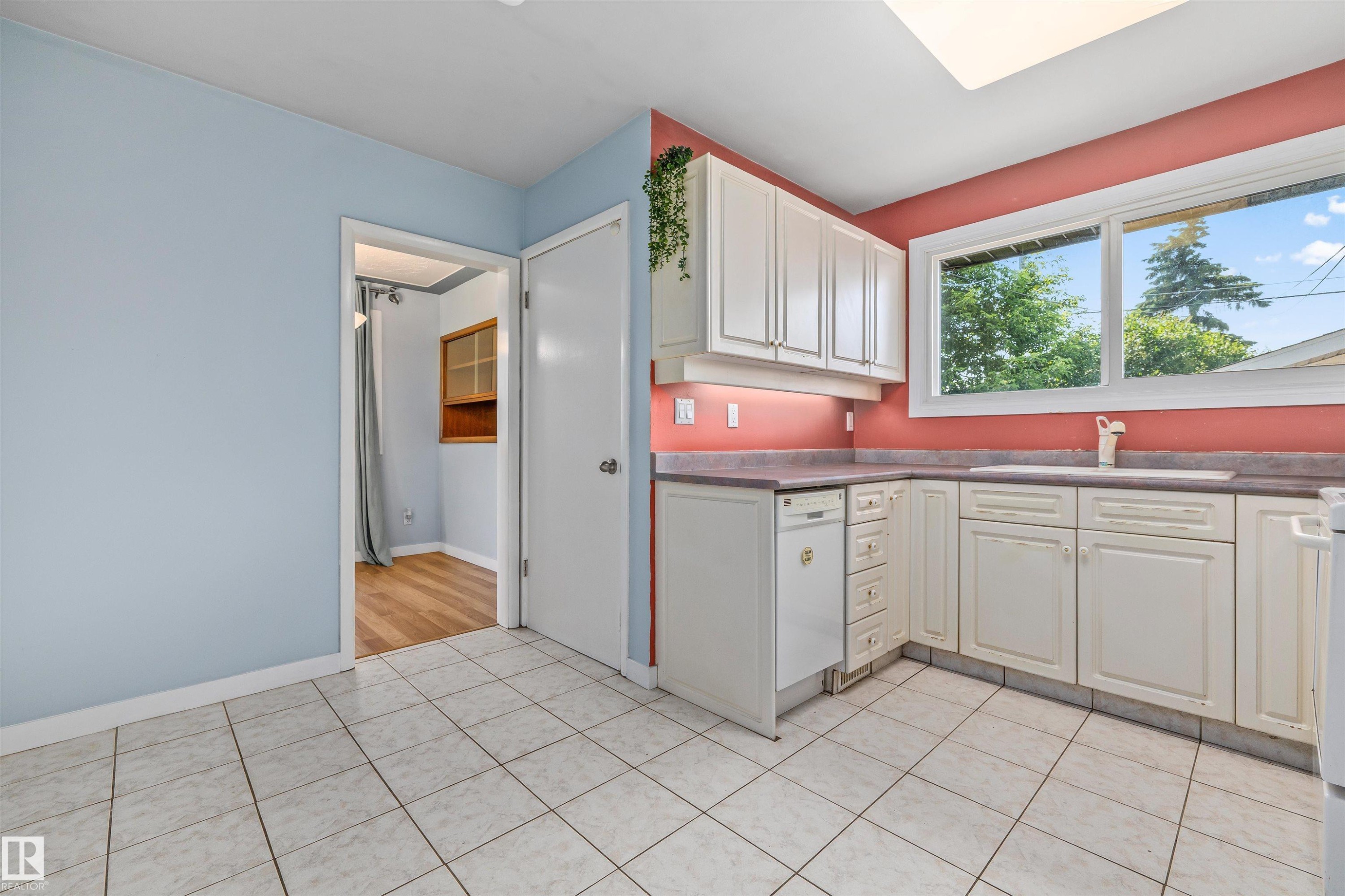 Kitchen featuring white cabinetry, a built-in dishwasher, tile flooring, and a window above the sink - 13320 123 Street Nw, Edmonton, AB - Indoor Photo Showing Kitchen