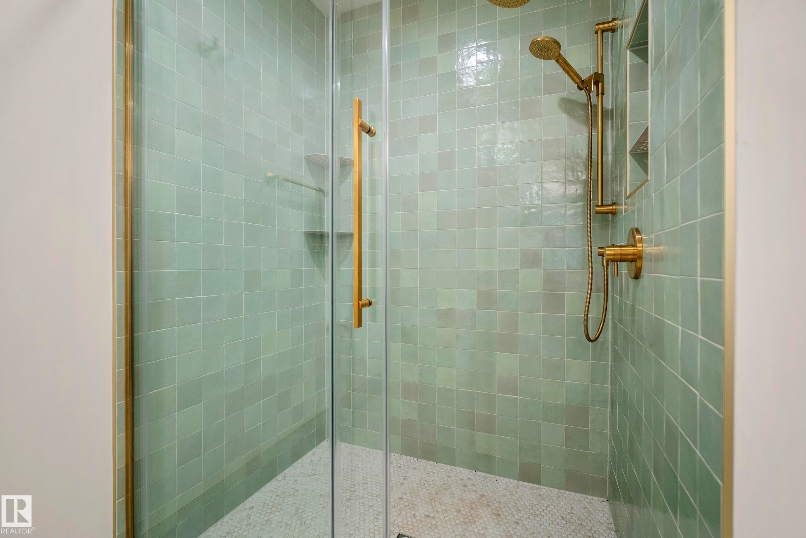 Glass-enclosed shower with square green wall tiles, gold-finish fixtures, and a recessed niche - 11006 64 Avenue Nw, Edmonton, AB