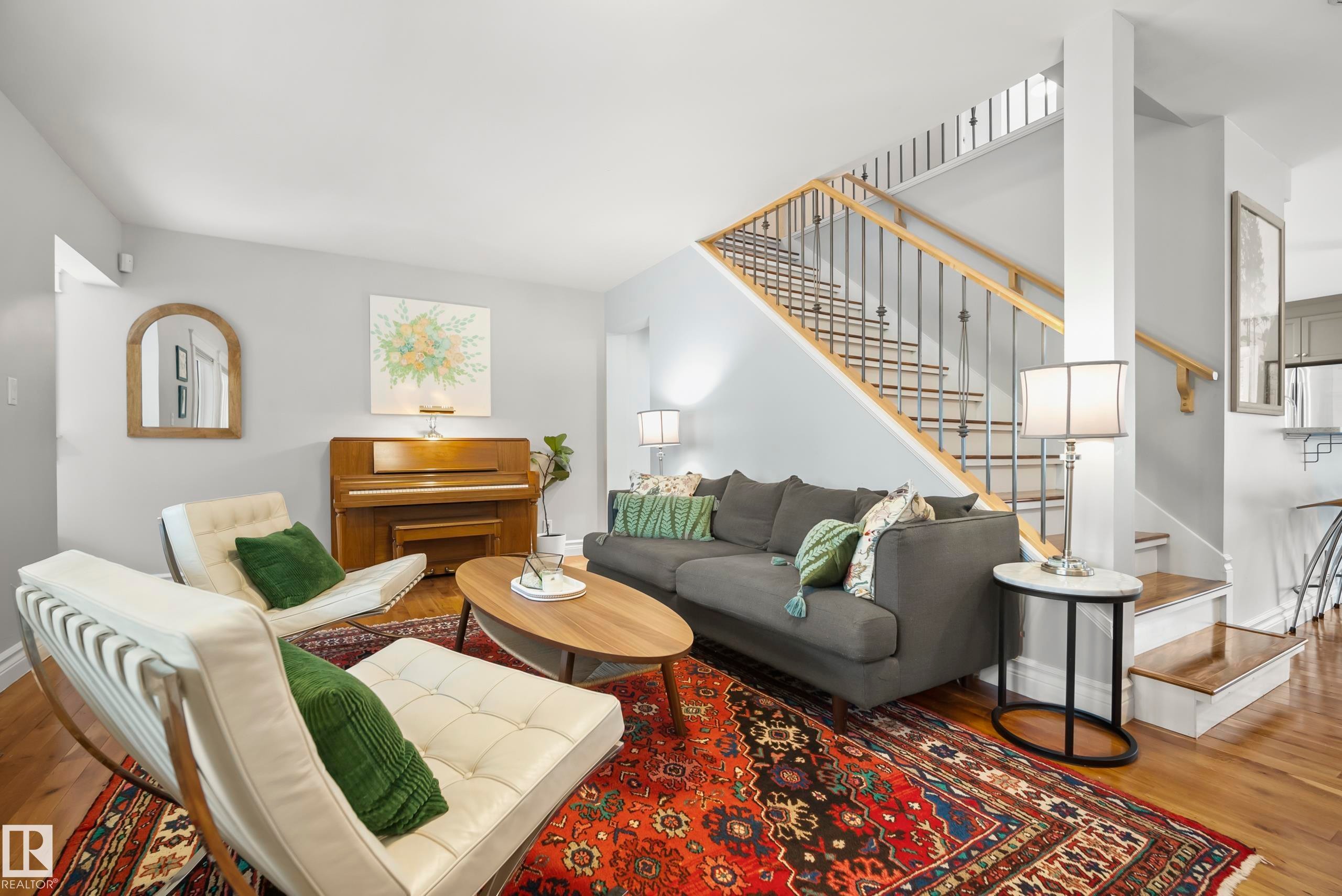 Hardwood flooring, painted walls, staircase with wood handrail and wrought iron balusters, recessed lighting, and a built-in pantry with a stainless steel appliance - 11006 64 Avenue Nw, Edmonton, AB