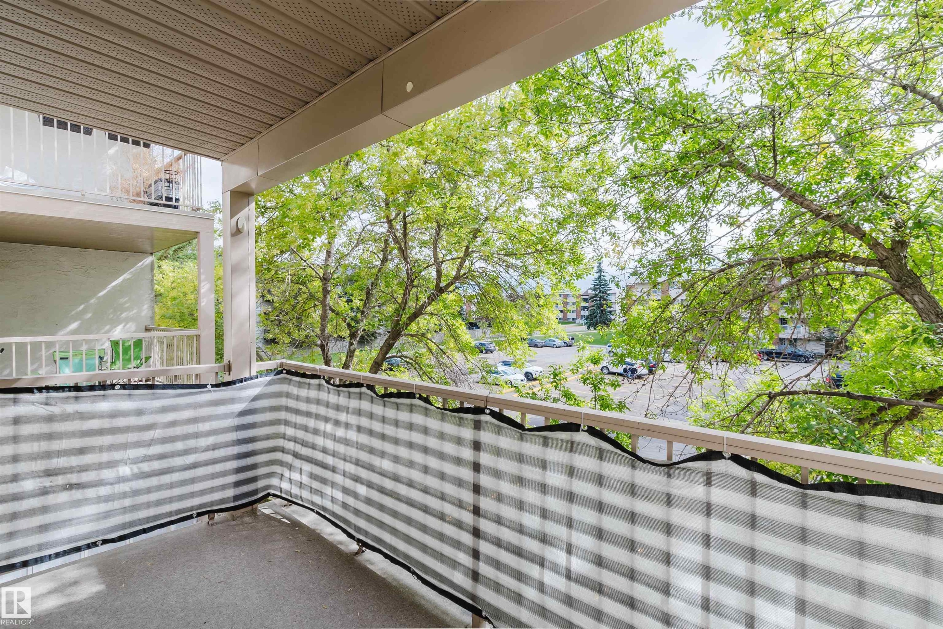 Balcony with concrete flooring and a striped privacy screen - #316 17109 67 Av Nw, Edmonton, AB