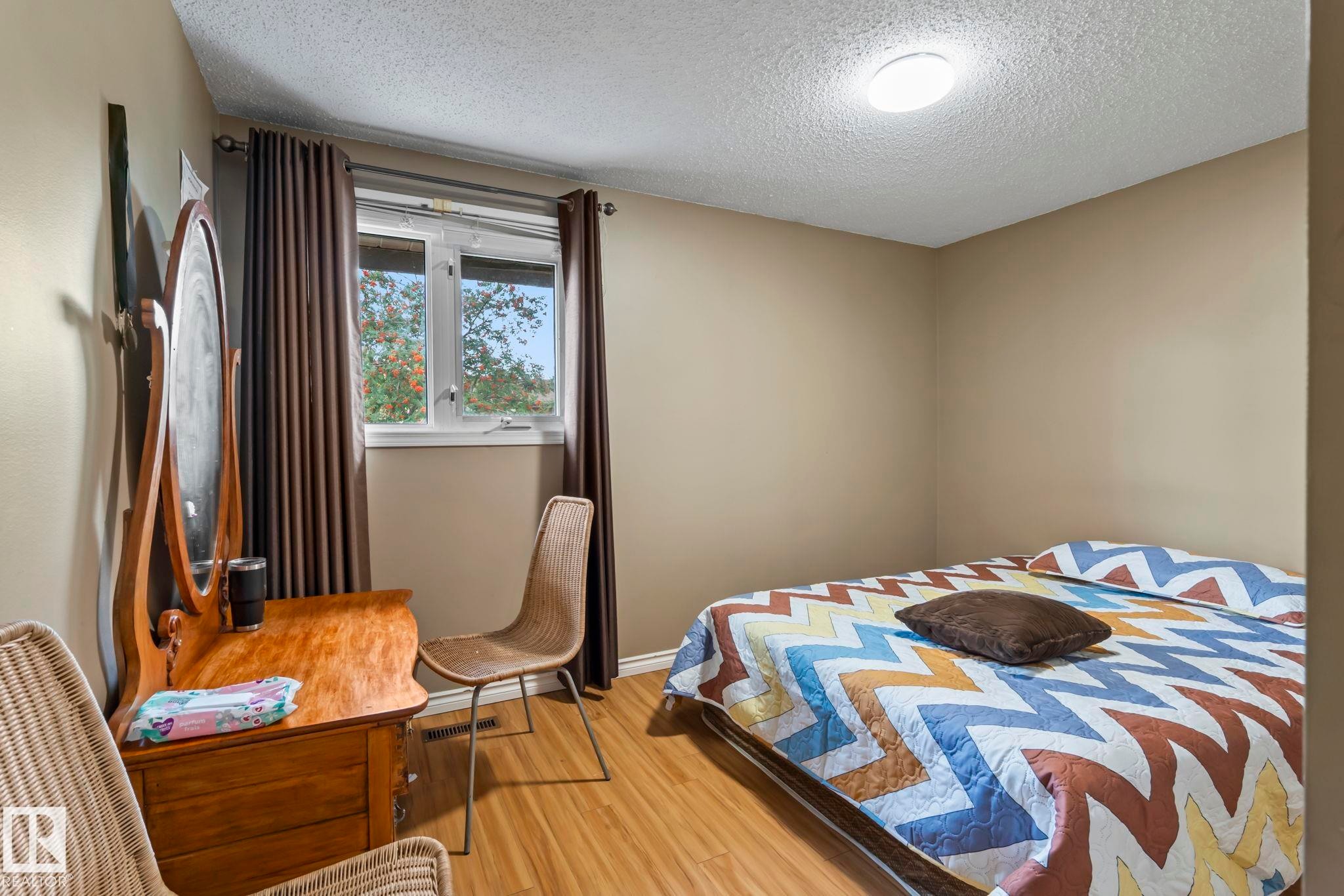 Wood-finish flooring, neutral wall paint, and a white framed window - 716 Clareview Rd Nw, Edmonton, AB