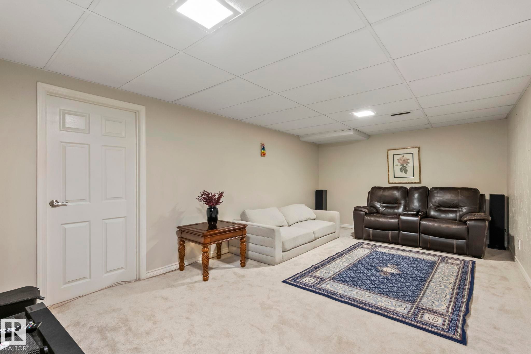 Recessed ceiling lighting, drop ceiling, neutral-toned carpeting, painted walls, and a paneled door - 716 Clareview Rd Nw, Edmonton, AB