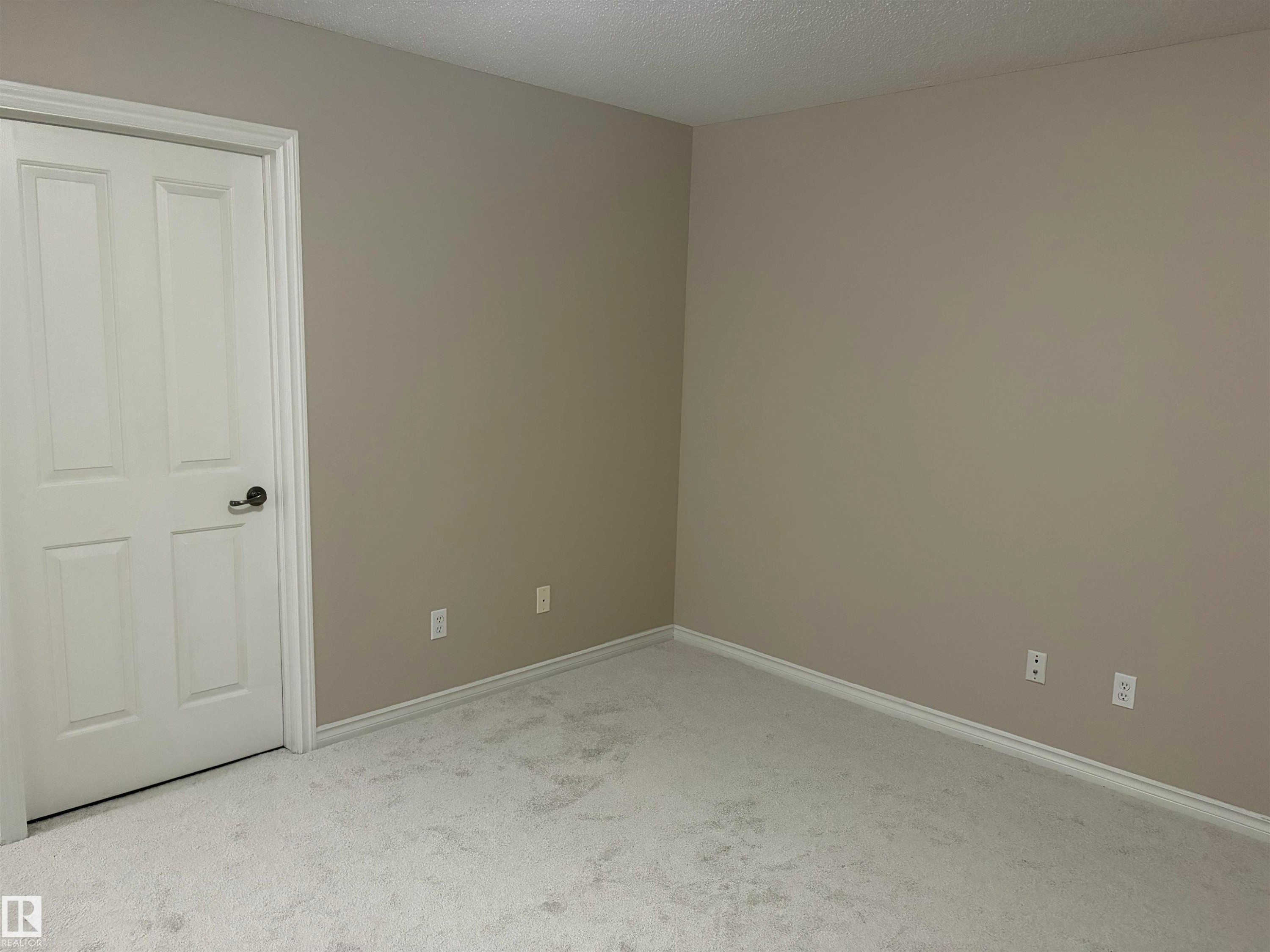 Light neutral wall color with crisp white trim and light-toned carpeting - #100 13825 155 Av Nw, Edmonton, AB