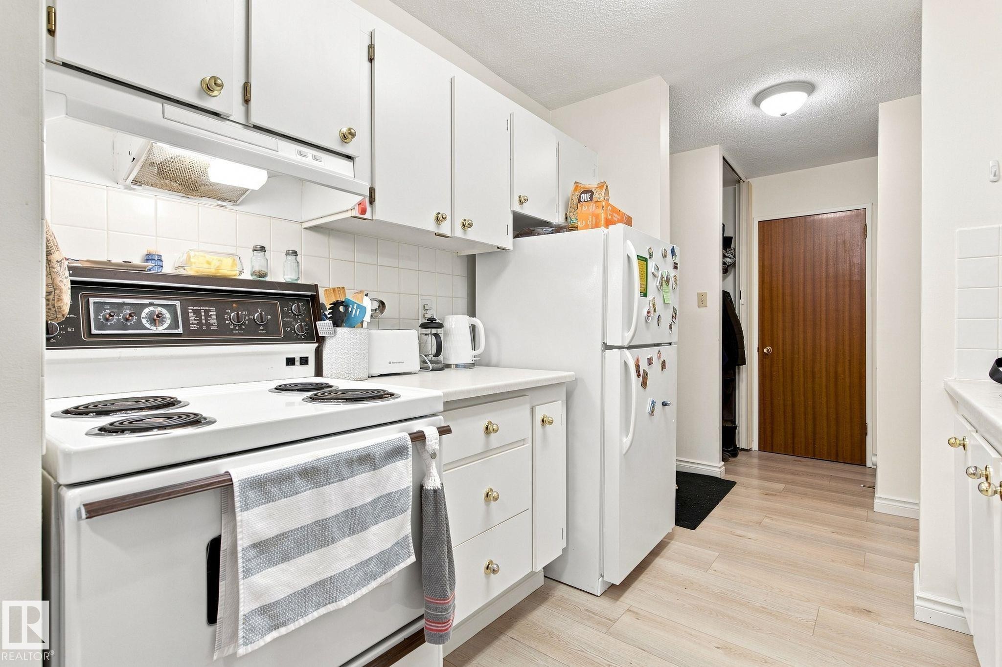 White cabinetry with gold-tone hardware - #1507 9835 113 St Nw, Edmonton, AB