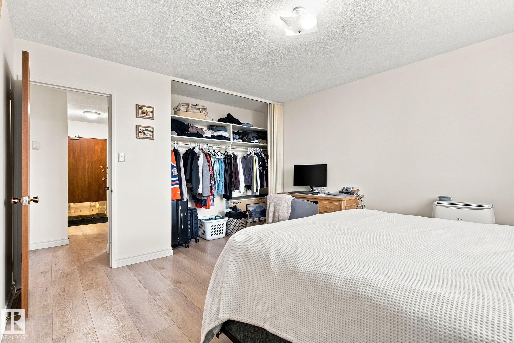 Wood-finish flooring throughout, integrated closet organization system, recessed ceiling light fixture, and solid core interior door - #1507 9835 113 St Nw, Edmonton, AB
