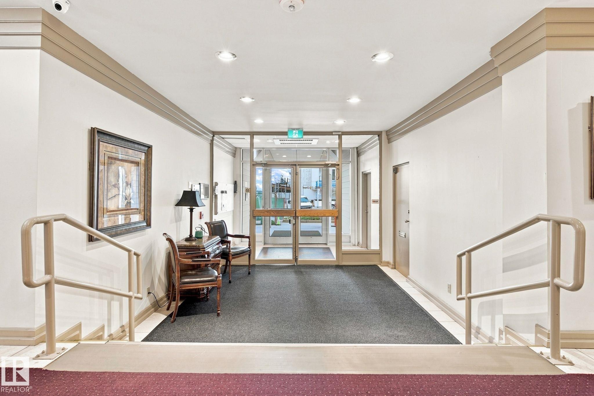 Entryway featuring glass double doors, recessed lighting, and a textured area rug - #1507 9835 113 St Nw, Edmonton, AB
