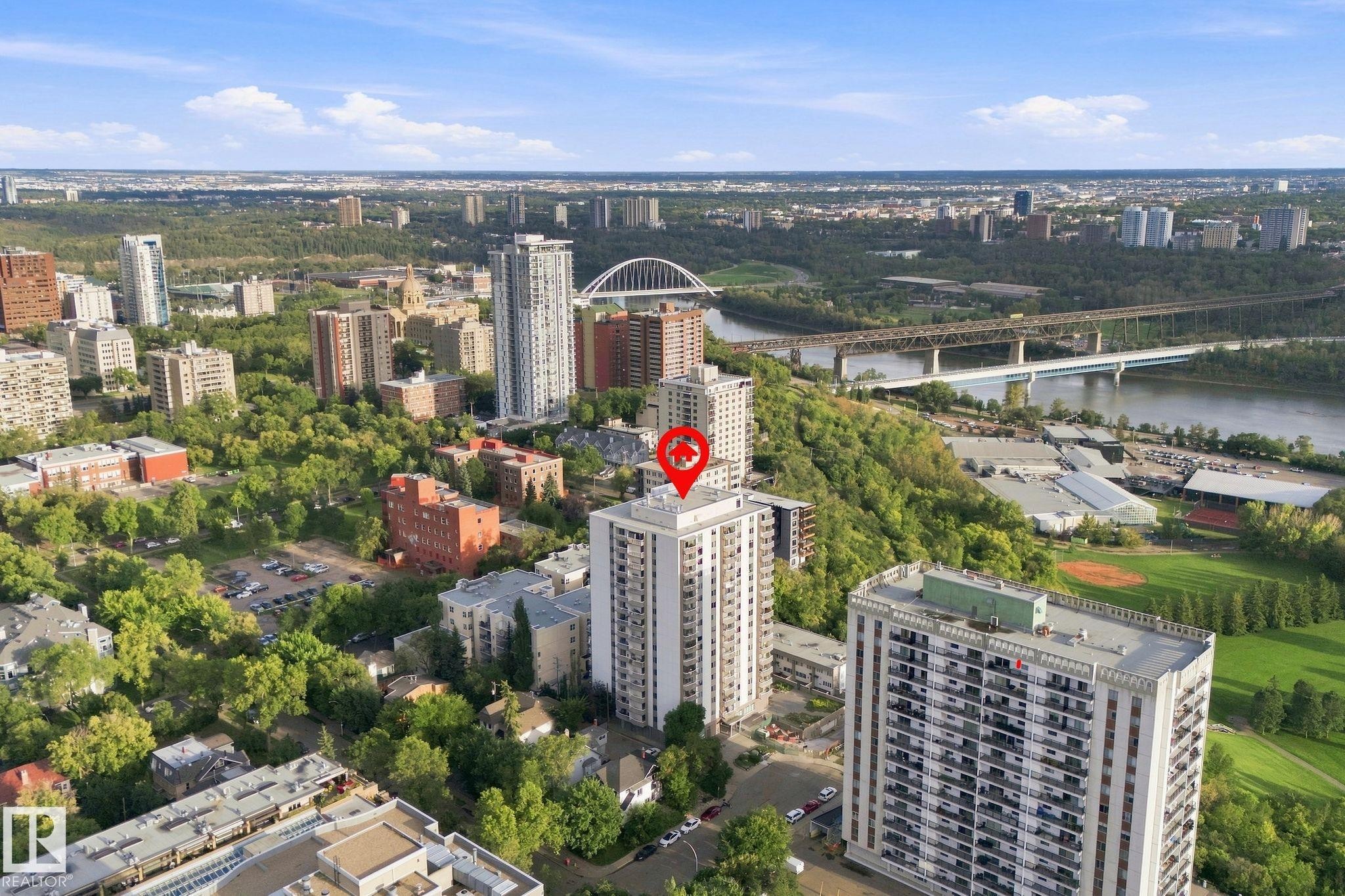 High-rise building situated within an urban landscape, featuring river access and surrounding green spaces - #1507 9835 113 St Nw, Edmonton, AB