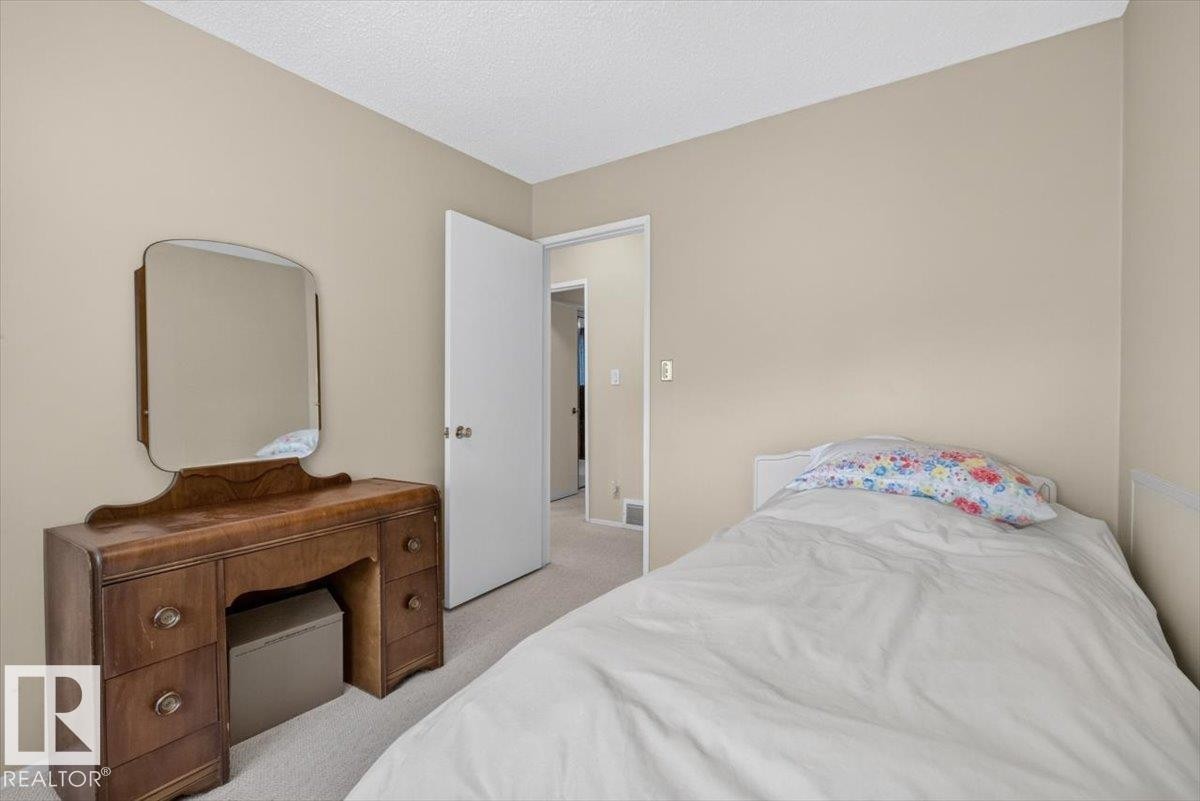 Neutral-toned walls complement light-colored carpeting throughout this space - 4027 74 Street Nw, Edmonton, AB - Indoor Photo Showing Bedroom
