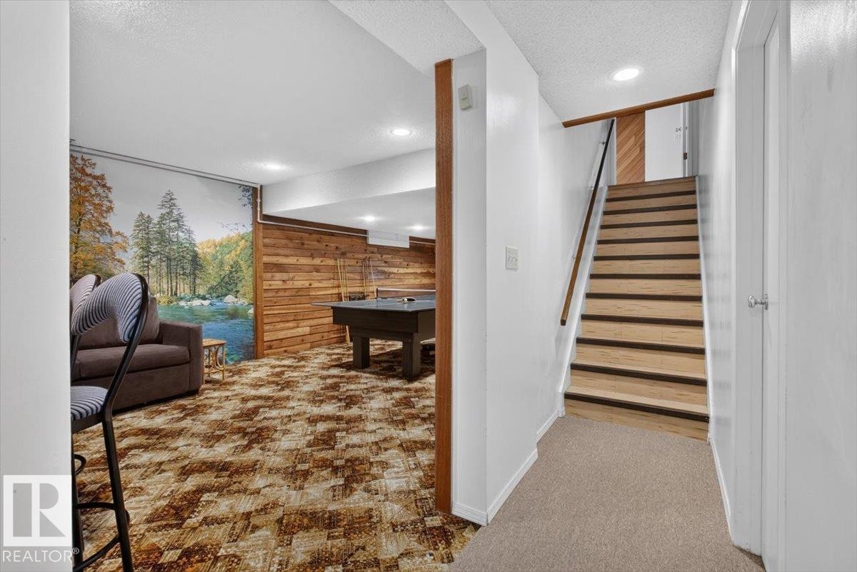 Recreation area with wood panel accent wall, recessed lighting, and patterned carpet - 4027 74 Street Nw, Edmonton, AB - Indoor Photo Showing Other Room