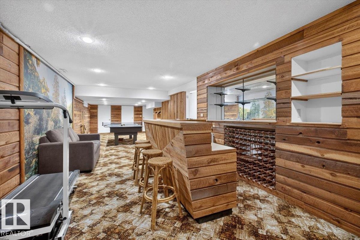 Finished basement featuring extensive wood paneling, recessed lighting, and a built-in bar with integrated wine storage - 4027 74 Street Nw, Edmonton, AB - Indoor Photo Showing Other Room