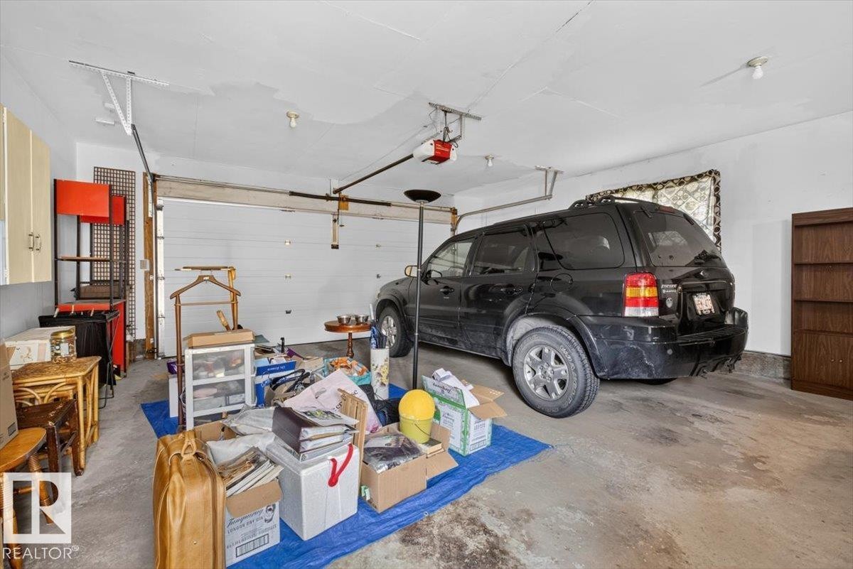 Garage featuring an overhead door and concrete flooring - 4027 74 Street Nw, Edmonton, AB - Indoor Photo Showing Garage