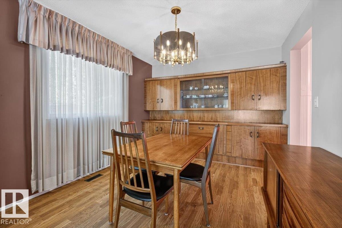 Built-in wood-finish cabinetry featuring glass-front display uppers and integrated lower storage - 4027 74 Street Nw, Edmonton, AB - Indoor Photo Showing Dining Room