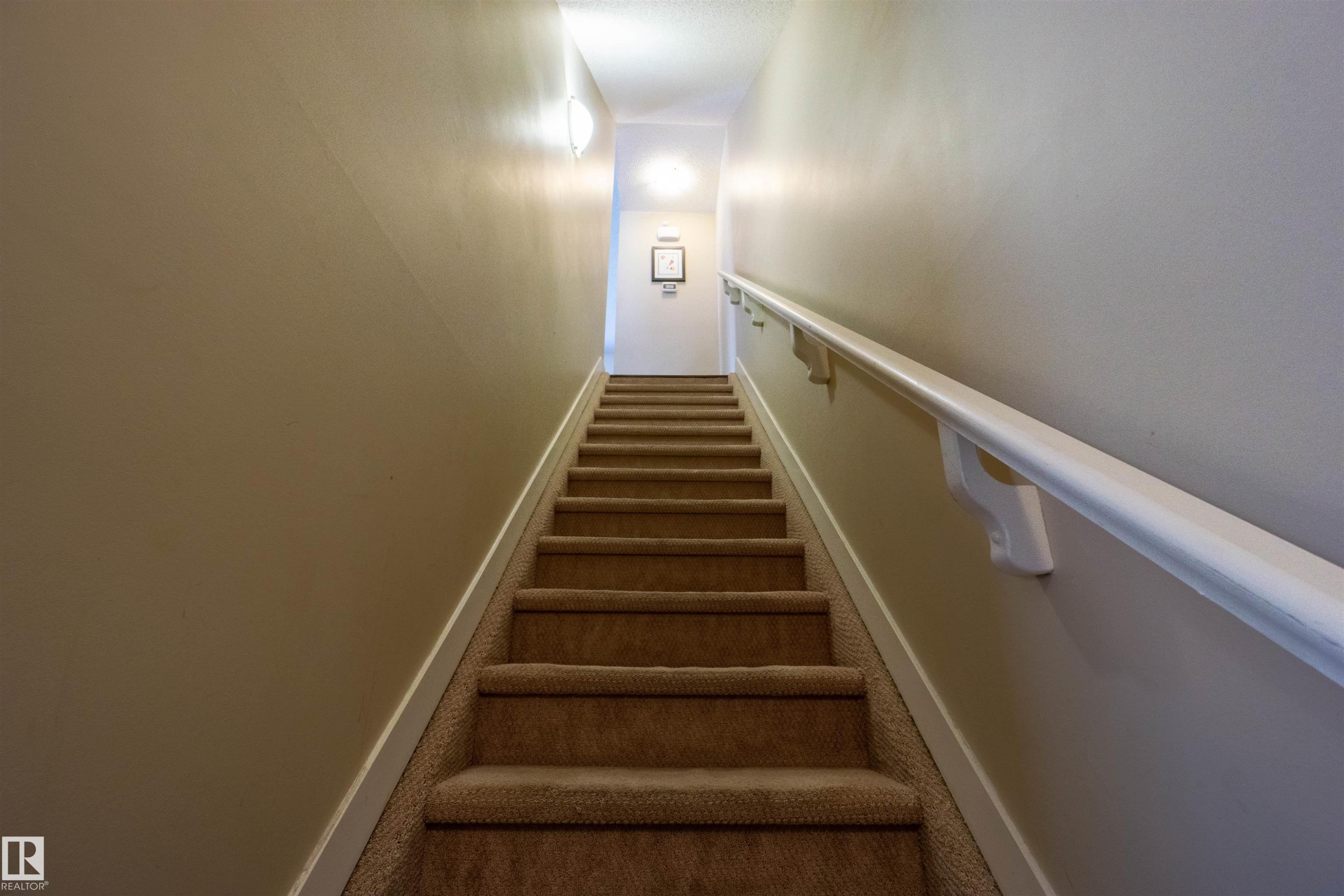Carpeted stairway featuring a handrail, wall sconce, and recessed lighting - #75 8315 180 Av Nw, Edmonton, AB