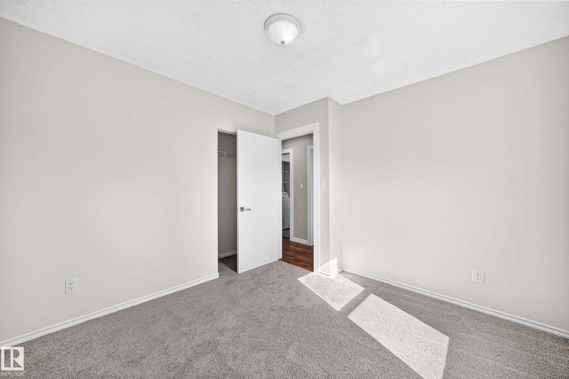 Neutral wall paint, gray carpet flooring, white trim, and a ceiling light fixture - 12721 117 Street Nw, Edmonton, AB
