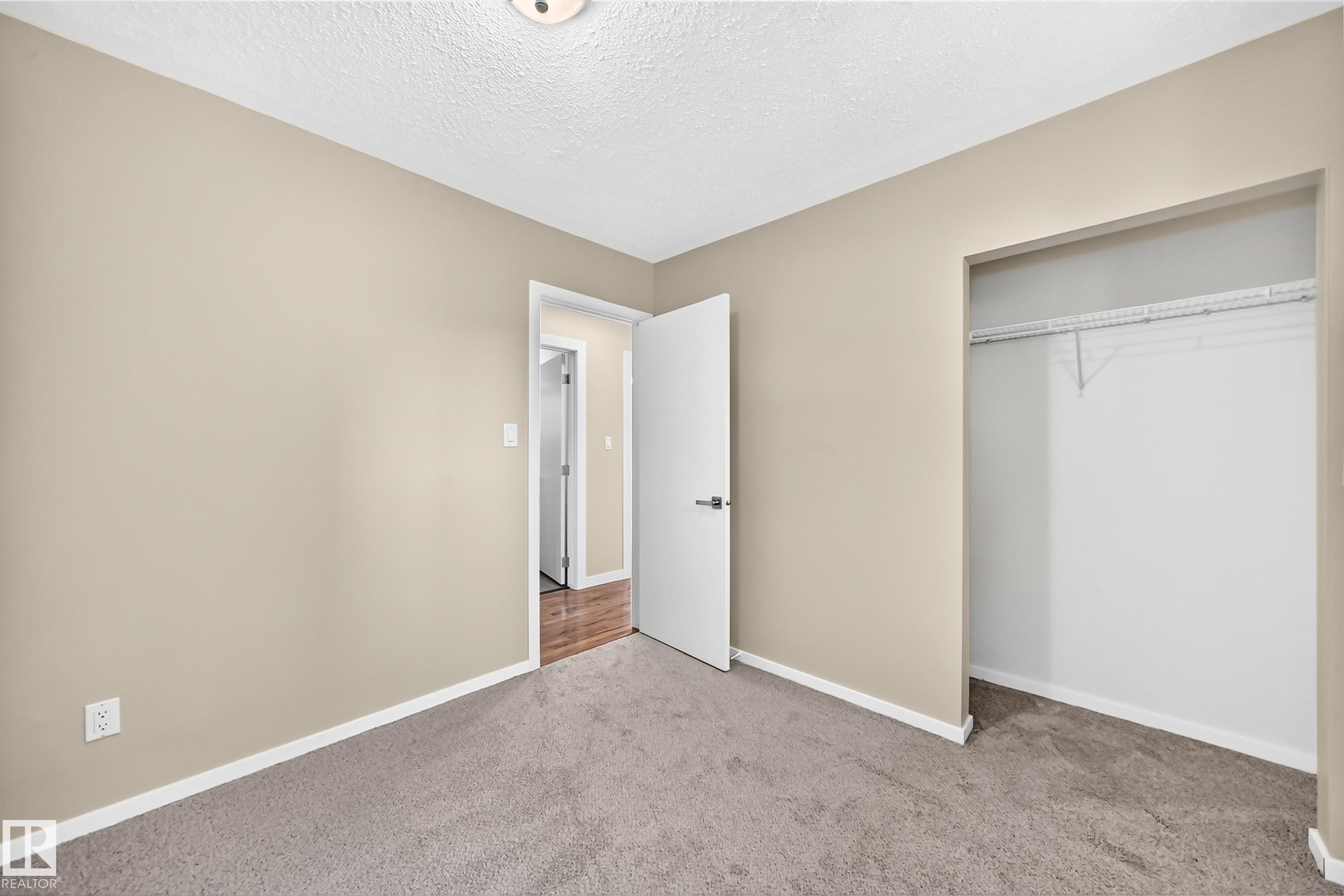 Neutral-toned walls complement plush carpeting - 12721 117 Street Nw, Edmonton, AB