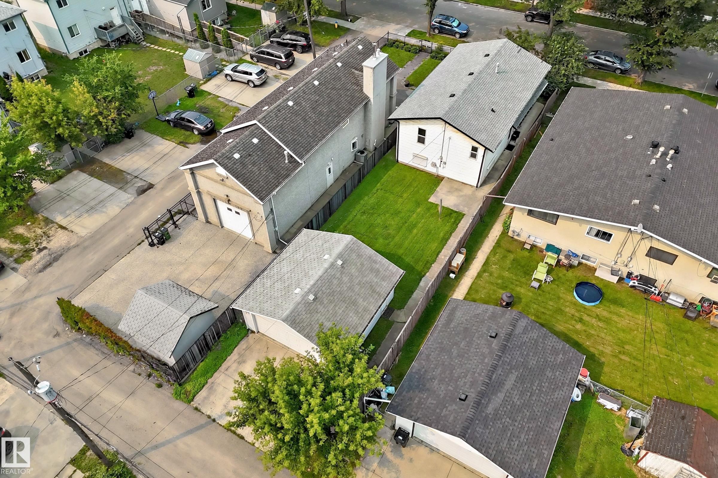 Property featuring multiple structures, a paved drive, and grassy areas - 12721 117 Street Nw, Edmonton, AB