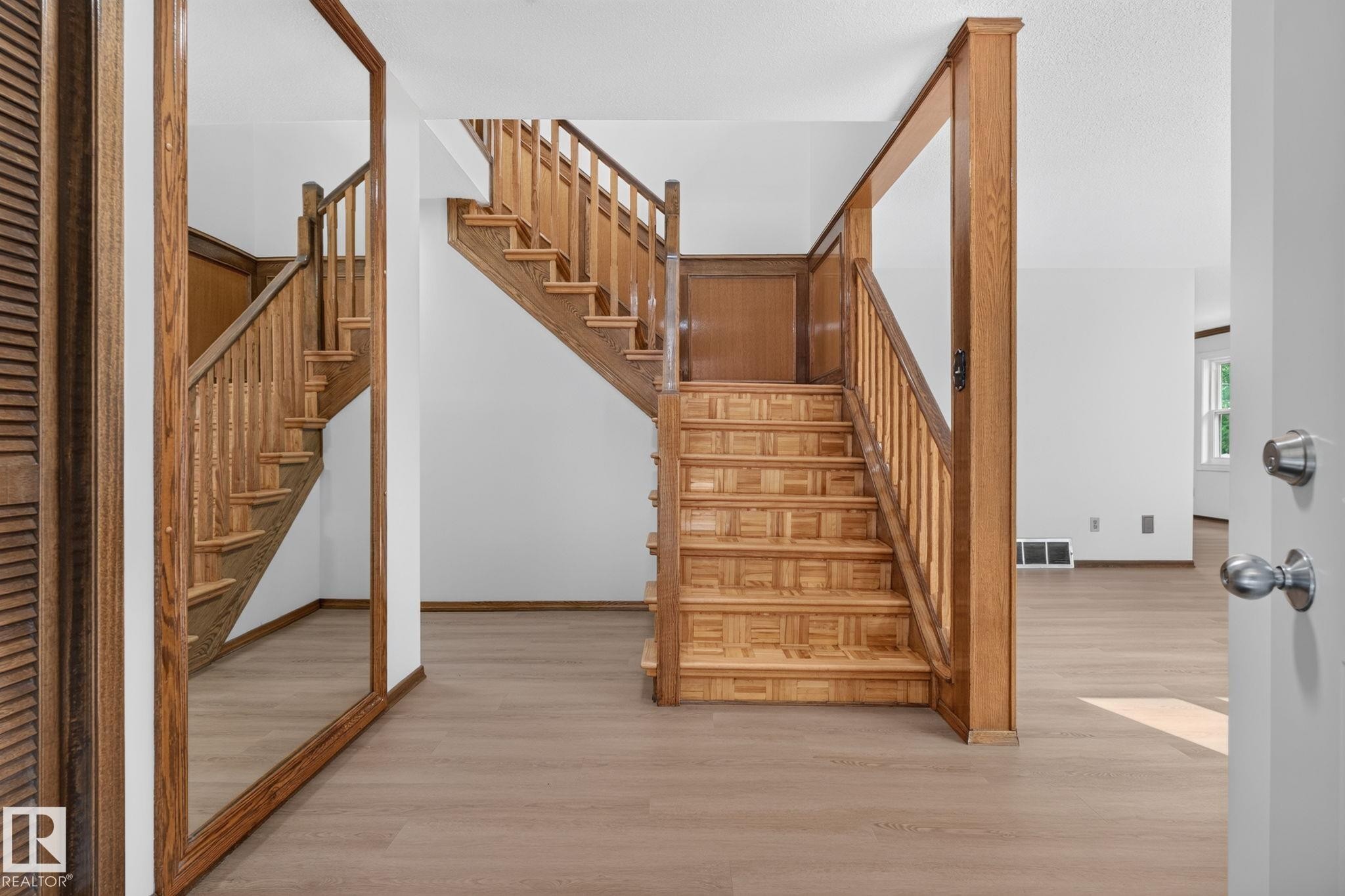 Hardwood staircase featuring patterned risers and baluster railing - 12121 42 Street Nw, Edmonton, AB - Indoor Photo Showing Other Room