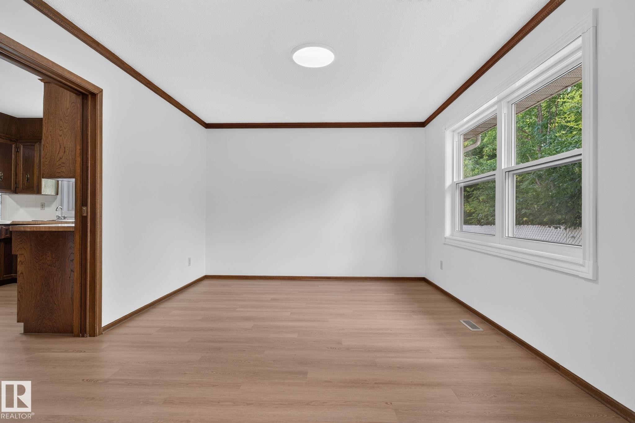 Room featuring wood-finish flooring, white walls, and a multi-pane window - 12121 42 Street Nw, Edmonton, AB - Indoor Photo Showing Other Room