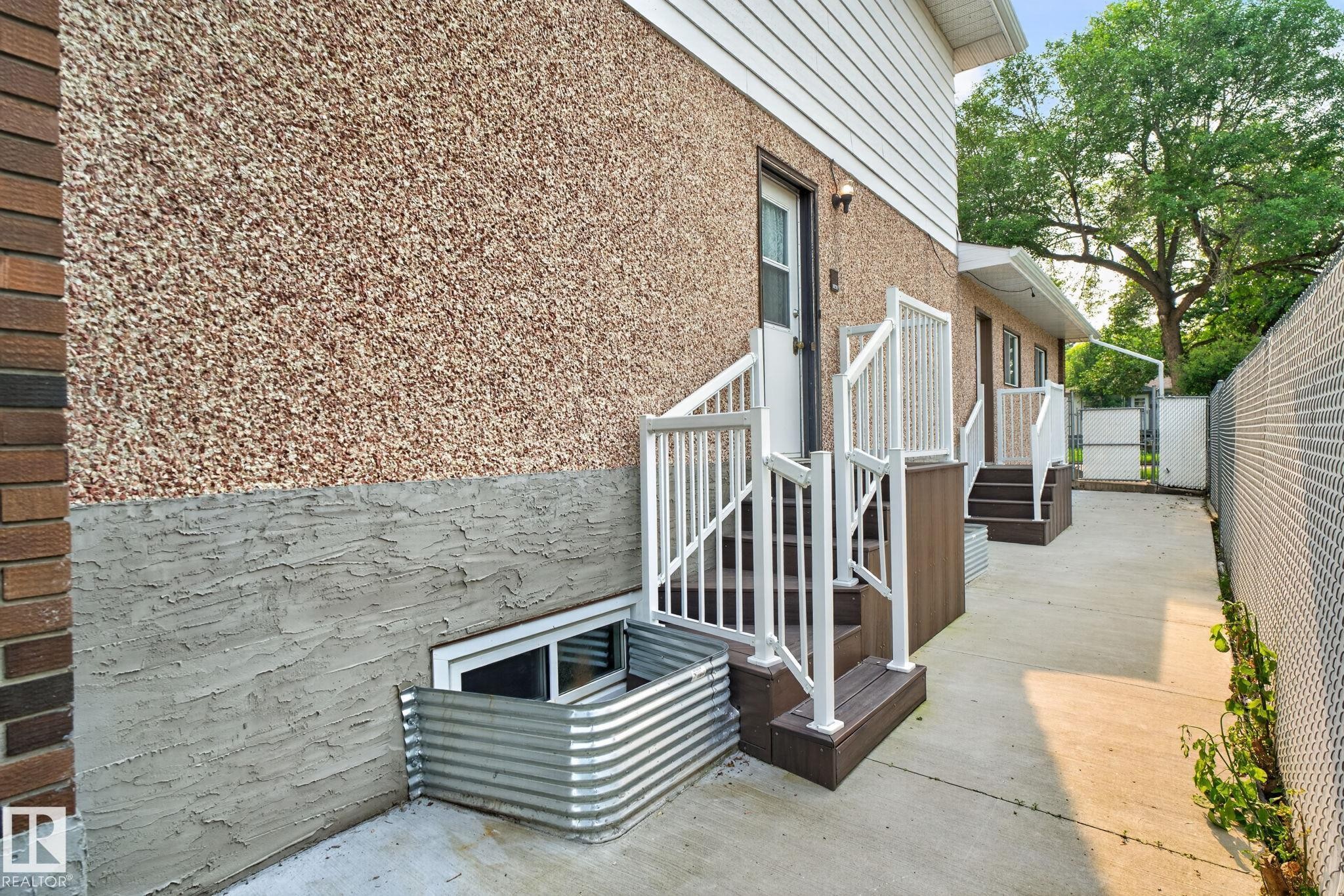 Exterior featuring textured stucco siding and brick accents - 12121 42 Street Nw, Edmonton, AB - Outdoor With Exterior