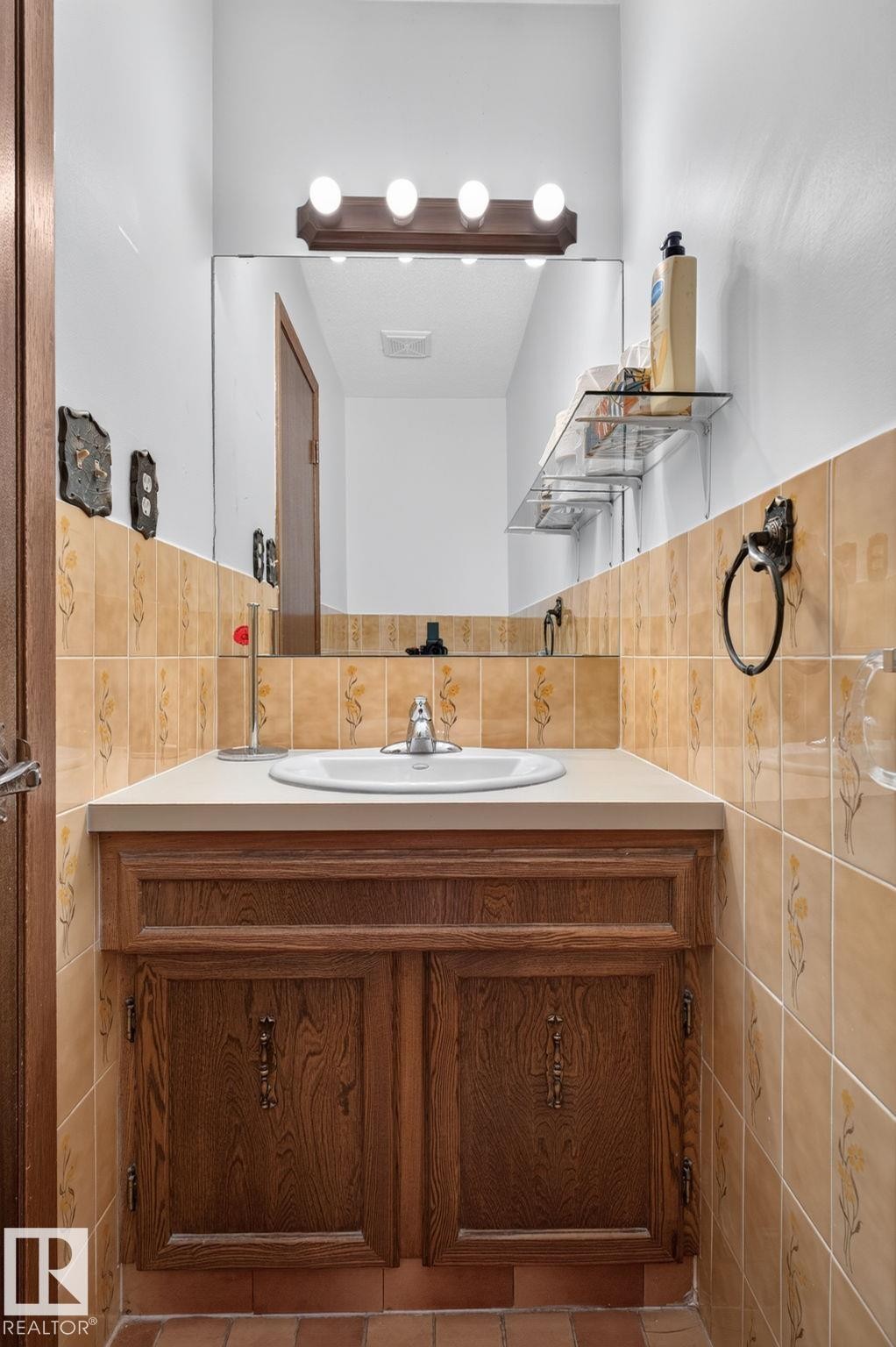 Bathroom vanity with wood-finish cabinetry, a drop-in sink, and a light-colored countertop - 12121 42 Street Nw, Edmonton, AB - Indoor Photo Showing Bathroom