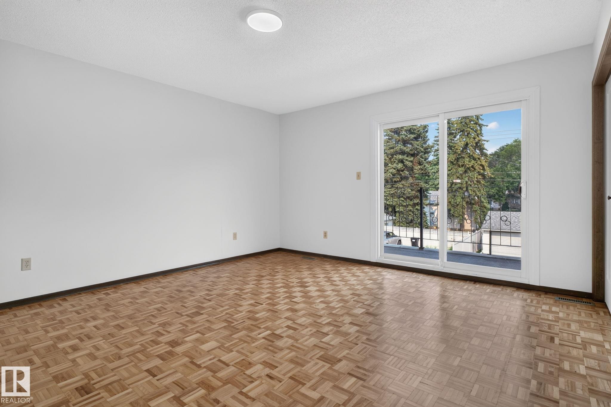 Room featuring light-toned walls and parquet wood-finish flooring - 12121 42 Street Nw, Edmonton, AB - Indoor Photo Showing Other Room