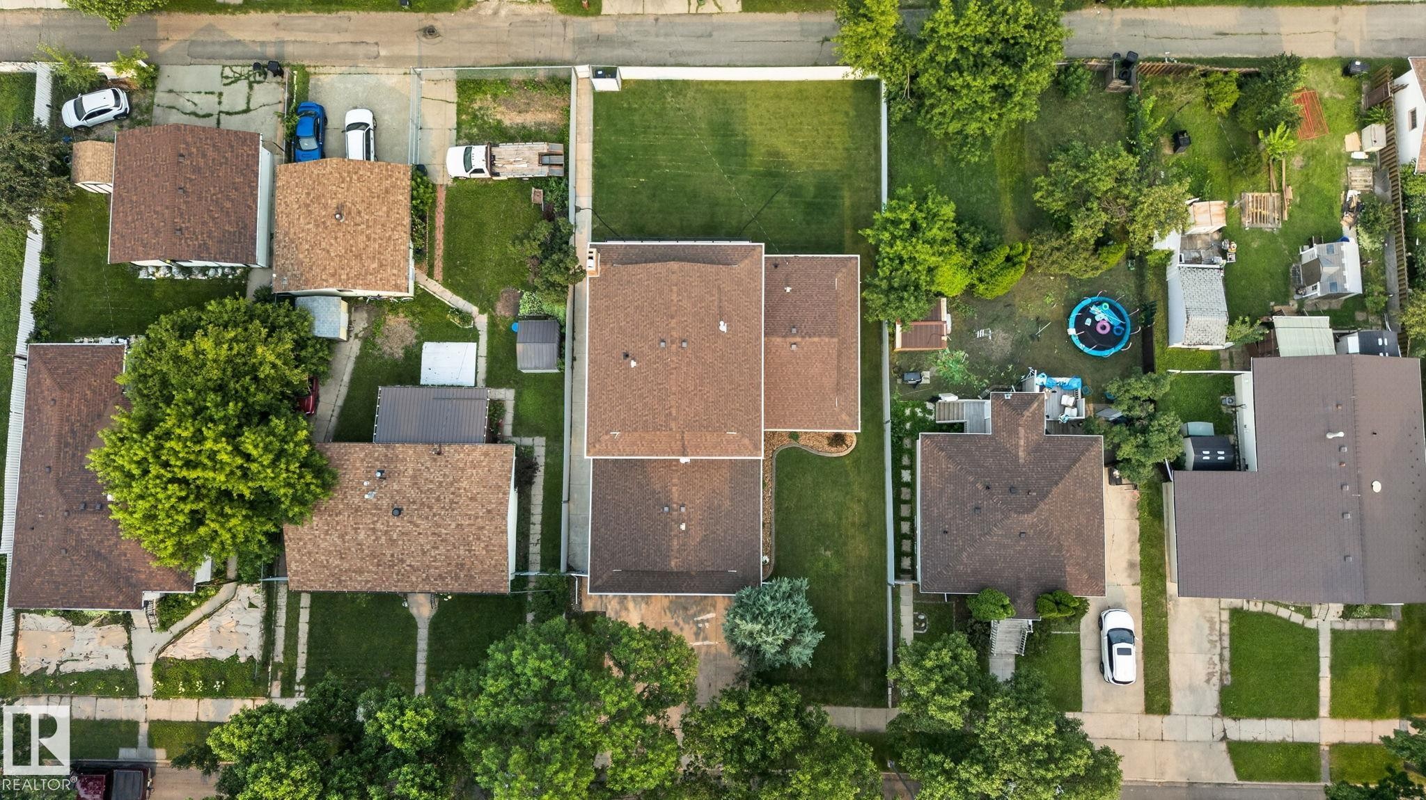 Spacious property featuring a large backyard, mature trees, and a paved driveway - 12121 42 Street Nw, Edmonton, AB -