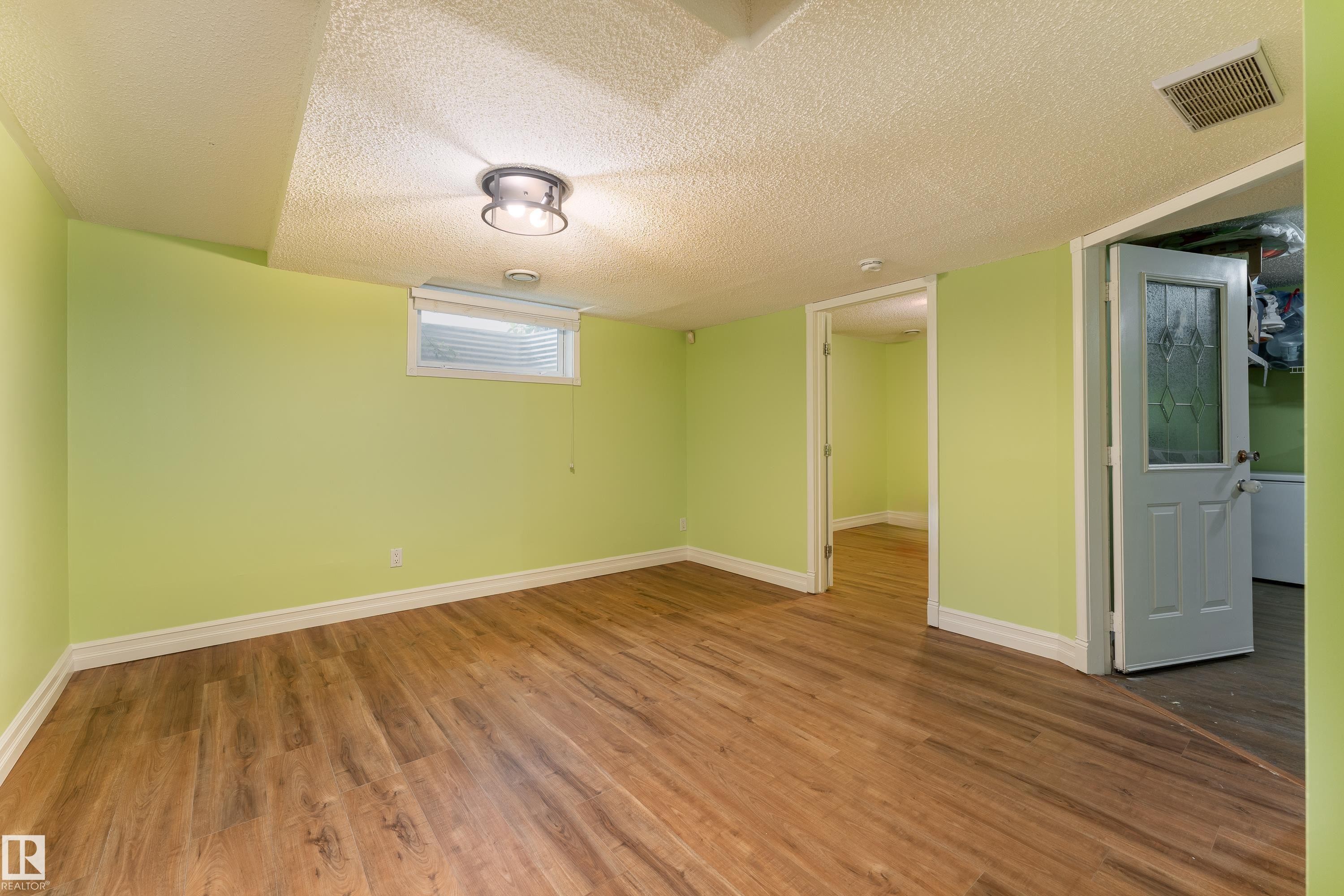 Wood-finish flooring, recessed ceiling lighting, light green wall paint, and white trim - 17928 93 Ave Nw, Edmonton, AB