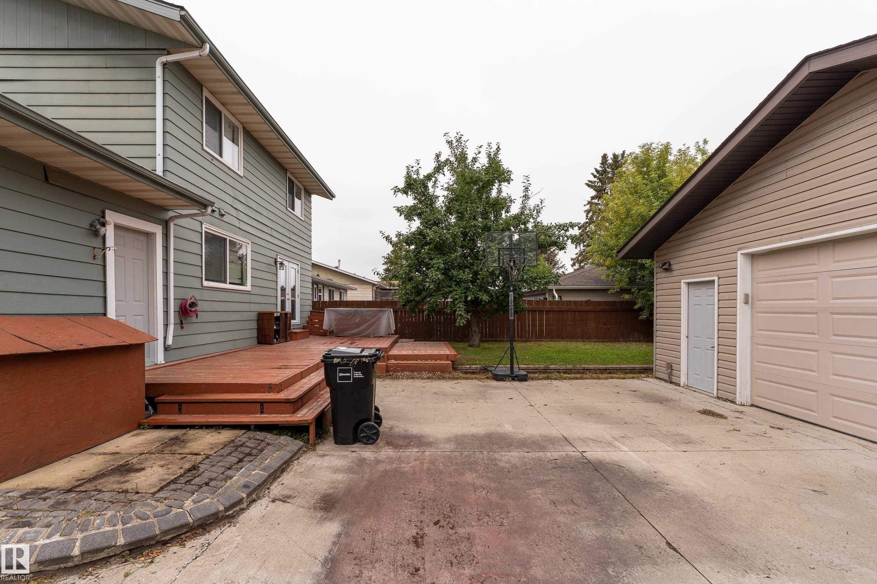 Expansive concrete driveway, detached two-car garage, and multi-level wood deck - 17928 93 Ave Nw, Edmonton, AB