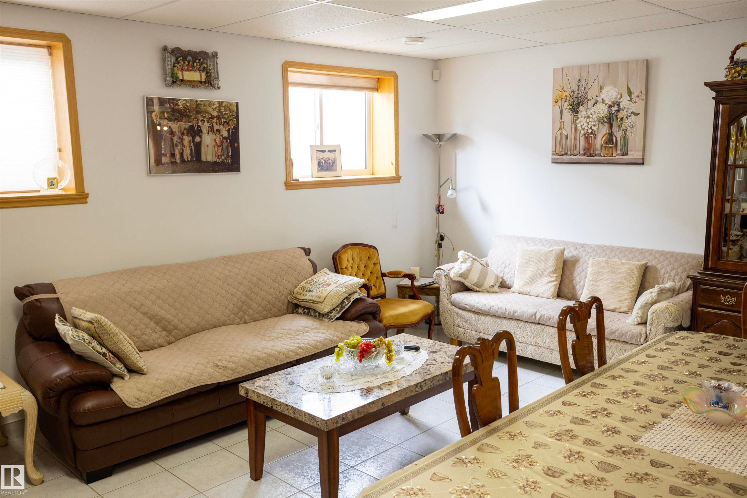 Brightly lit living space featuring two windows with wood trim and white blinds - 6407 163 Avenue Nw, Edmonton, AB