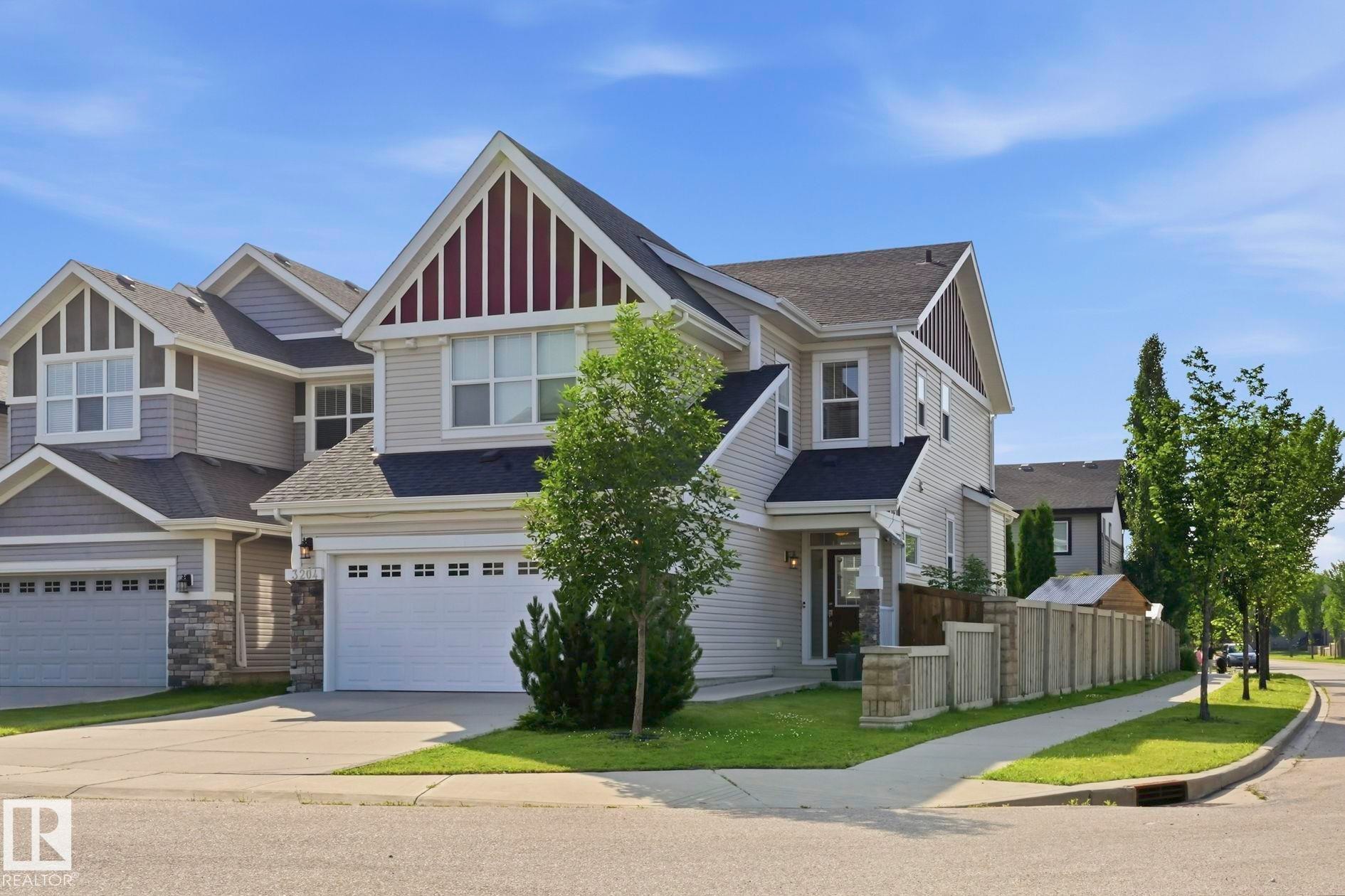 Two-story residence featuring light gray siding, dark roofing, and a prominent front-facing gable with vertical accents - 3204 Abbott Crescent Sw, Edmonton, AB - Outdoor With Facade