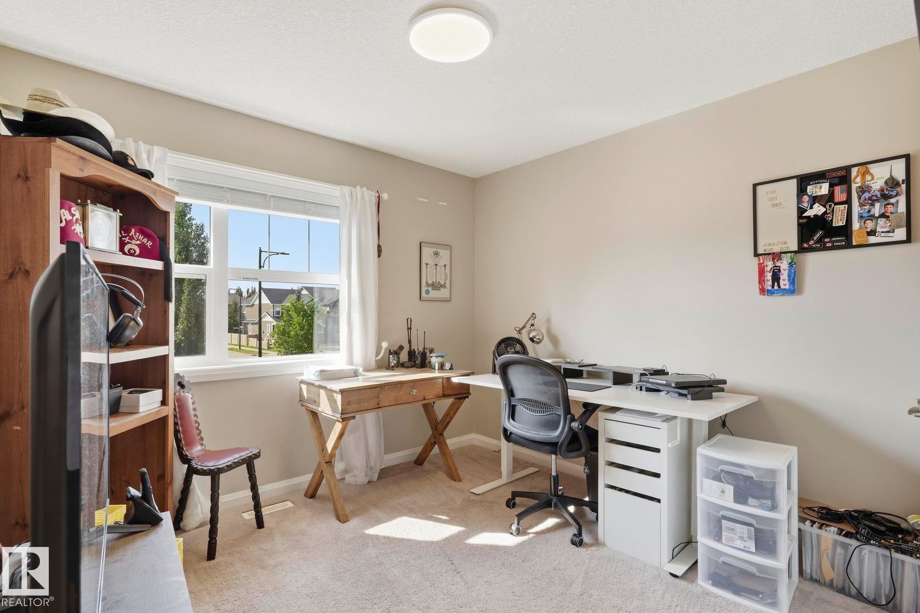 Carpeted room with a double-pane window, flush-mount ceiling light, and neutral wall color - 3204 Abbott Crescent Sw, Edmonton, AB - Indoor Photo Showing Office