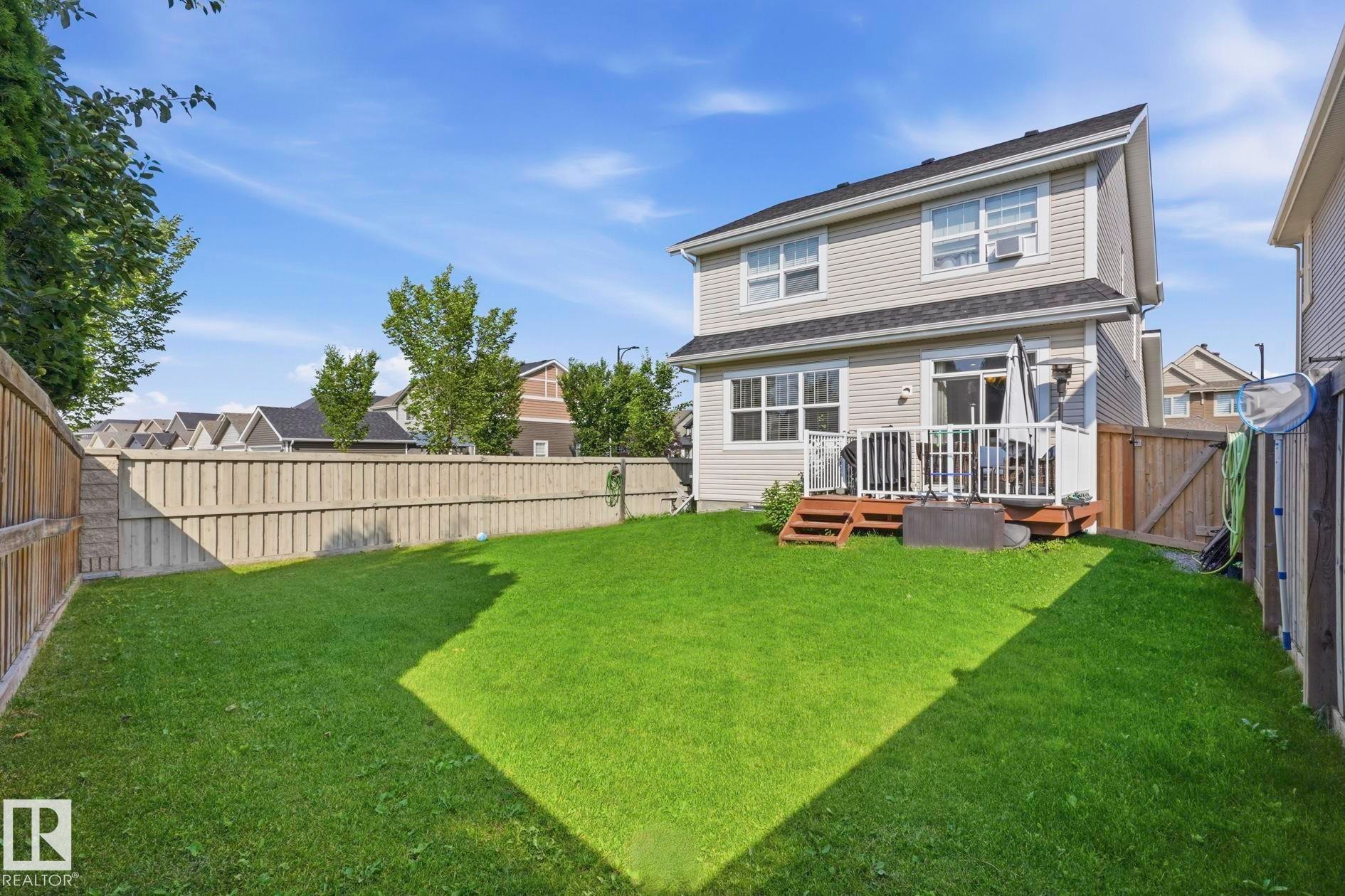 Spacious backyard with a large lawn, private fencing, and a multi-level wood deck - 3204 Abbott Crescent Sw, Edmonton, AB - Outdoor With Deck Patio Veranda