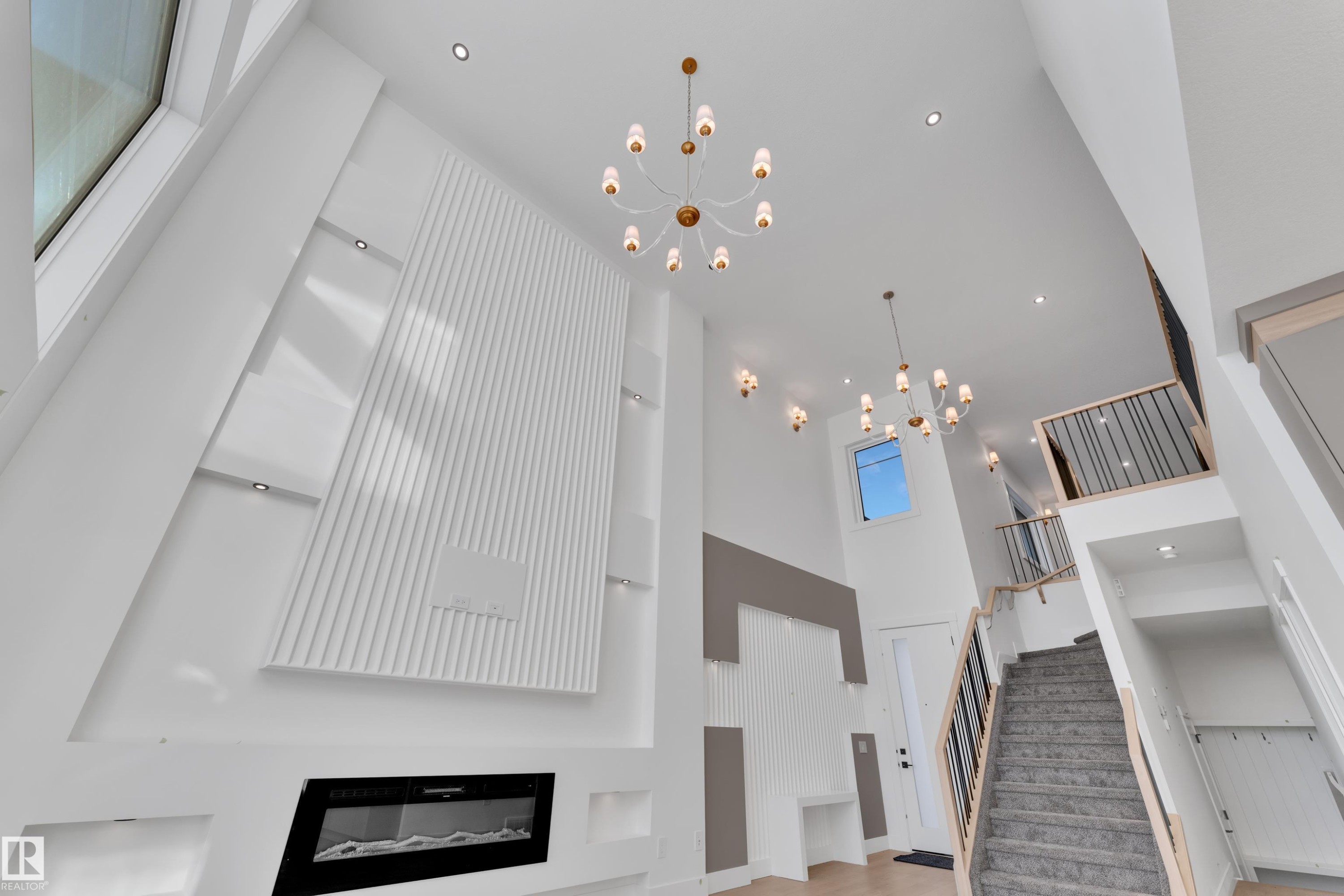 Two-story ceiling with recessed lighting and two contemporary chandeliers - 226 Linden Loop, Leduc, AB