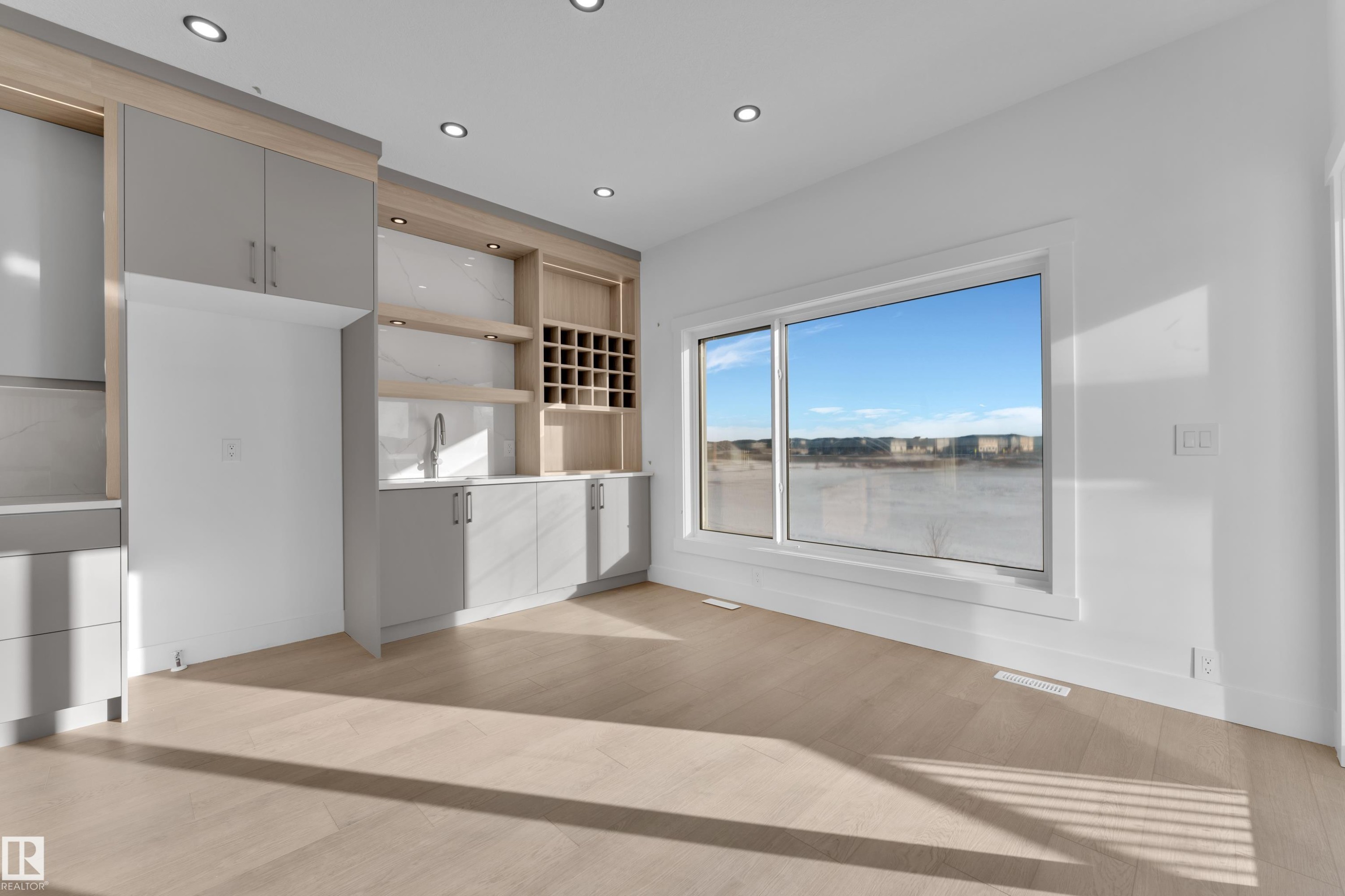 Built-in cabinetry with light wood-finish accents, integrated shelving, and a beverage cooler - 226 Linden Loop, Leduc, AB