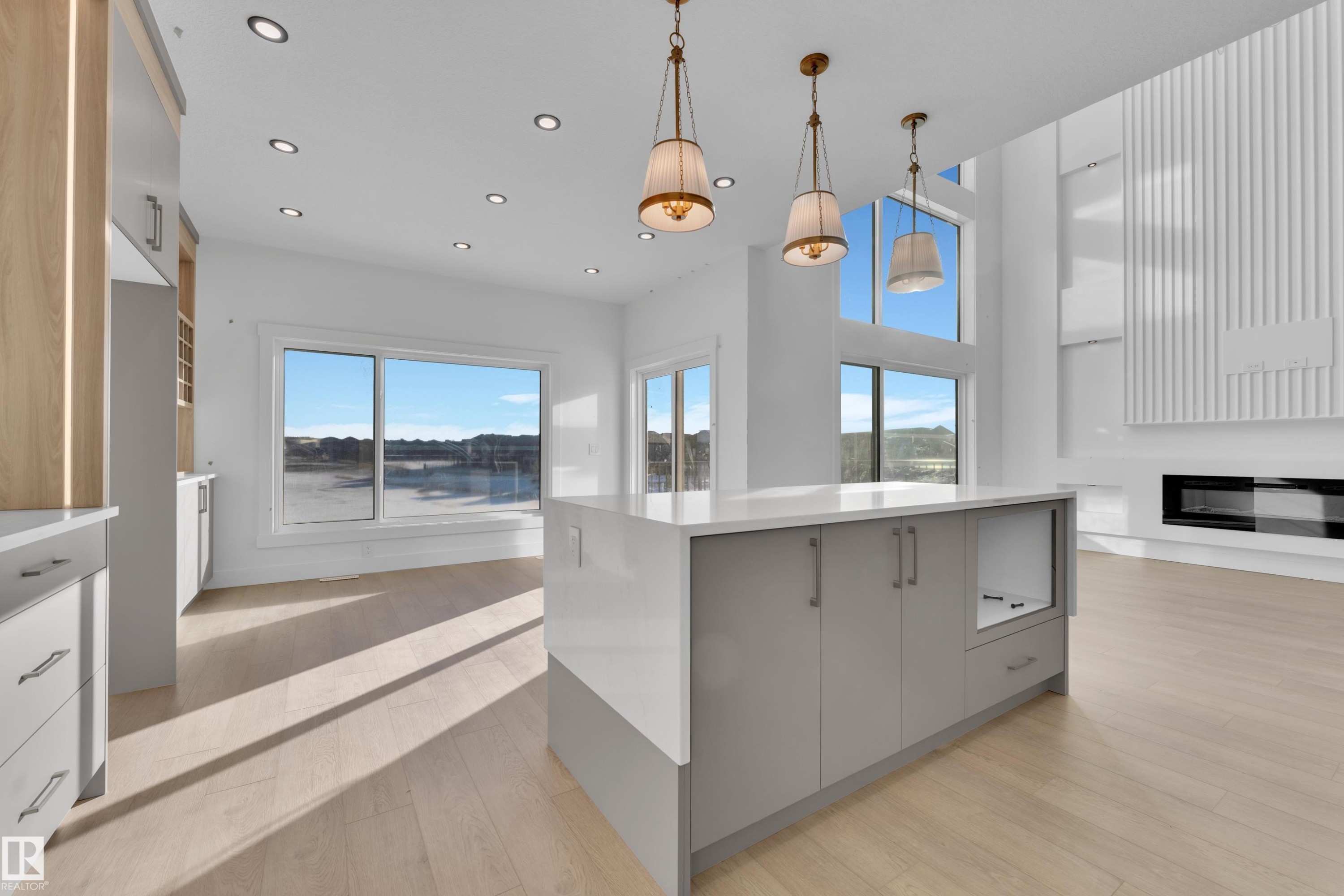 Kitchen island with light grey cabinetry and a solid surface countertop - 226 Linden Loop, Leduc, AB