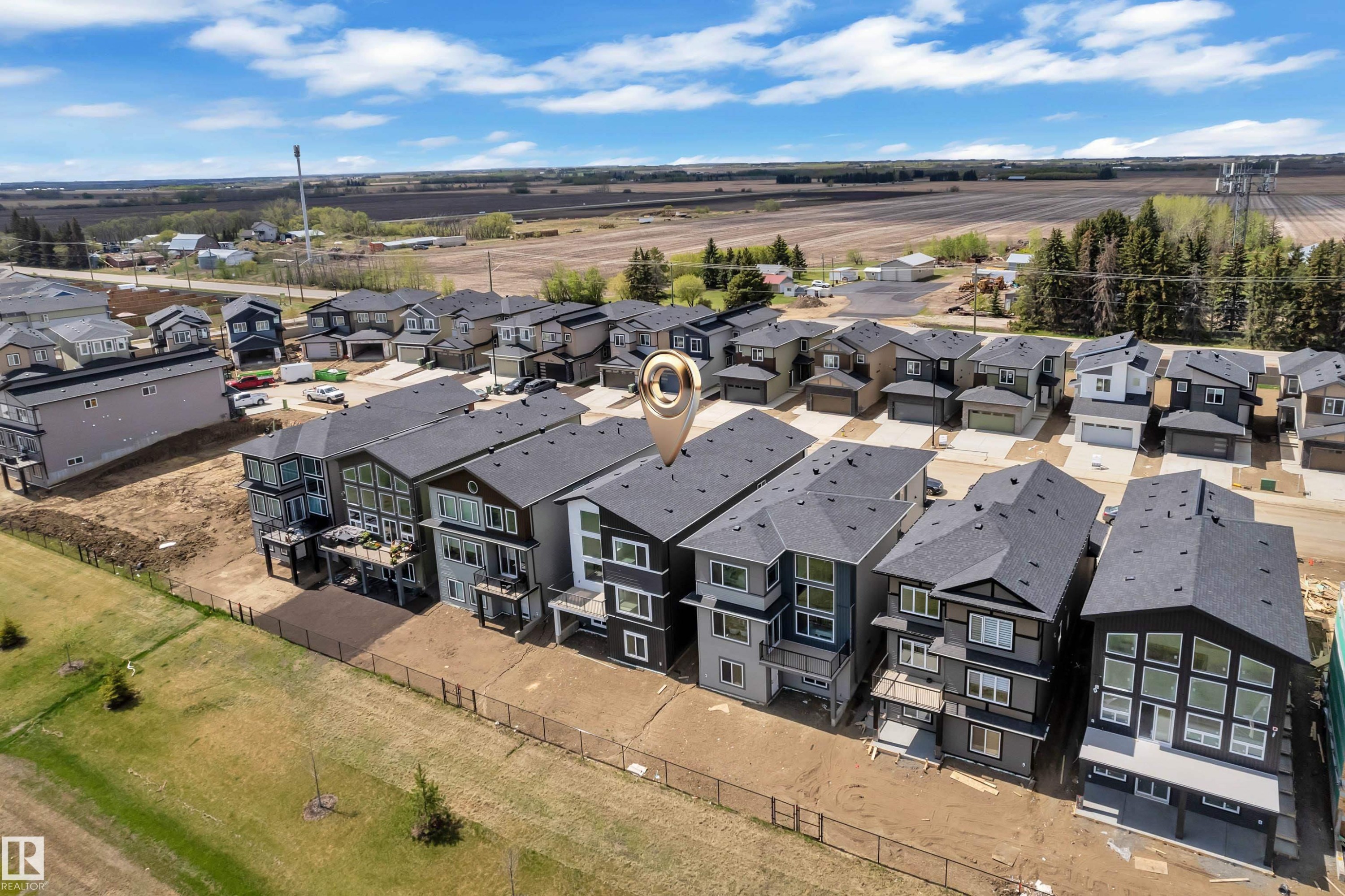 Modern residential development with multi-story homes featuring dark-toned siding, attached garages, and private balconies - 226 Linden Loop, Leduc, AB