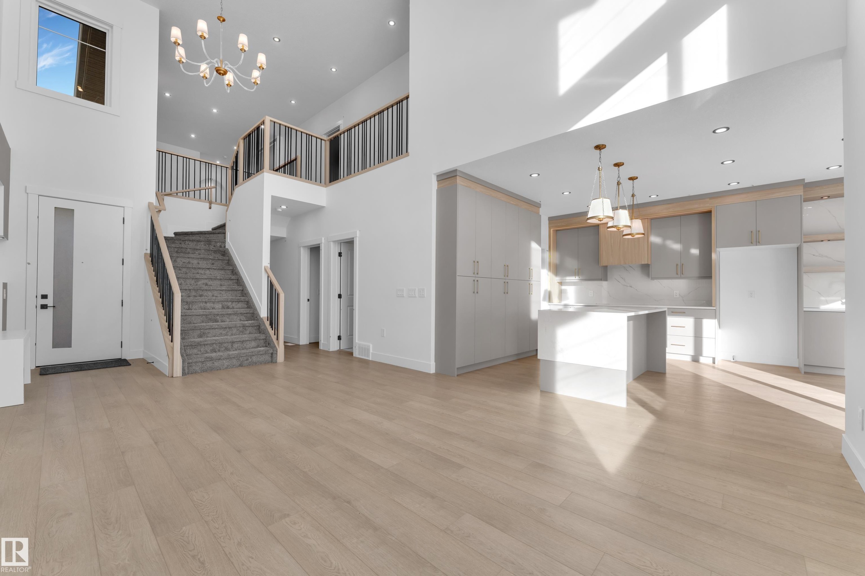 Two-story foyer with a decorative chandelier and recessed lighting - 226 Linden Loop, Leduc, AB