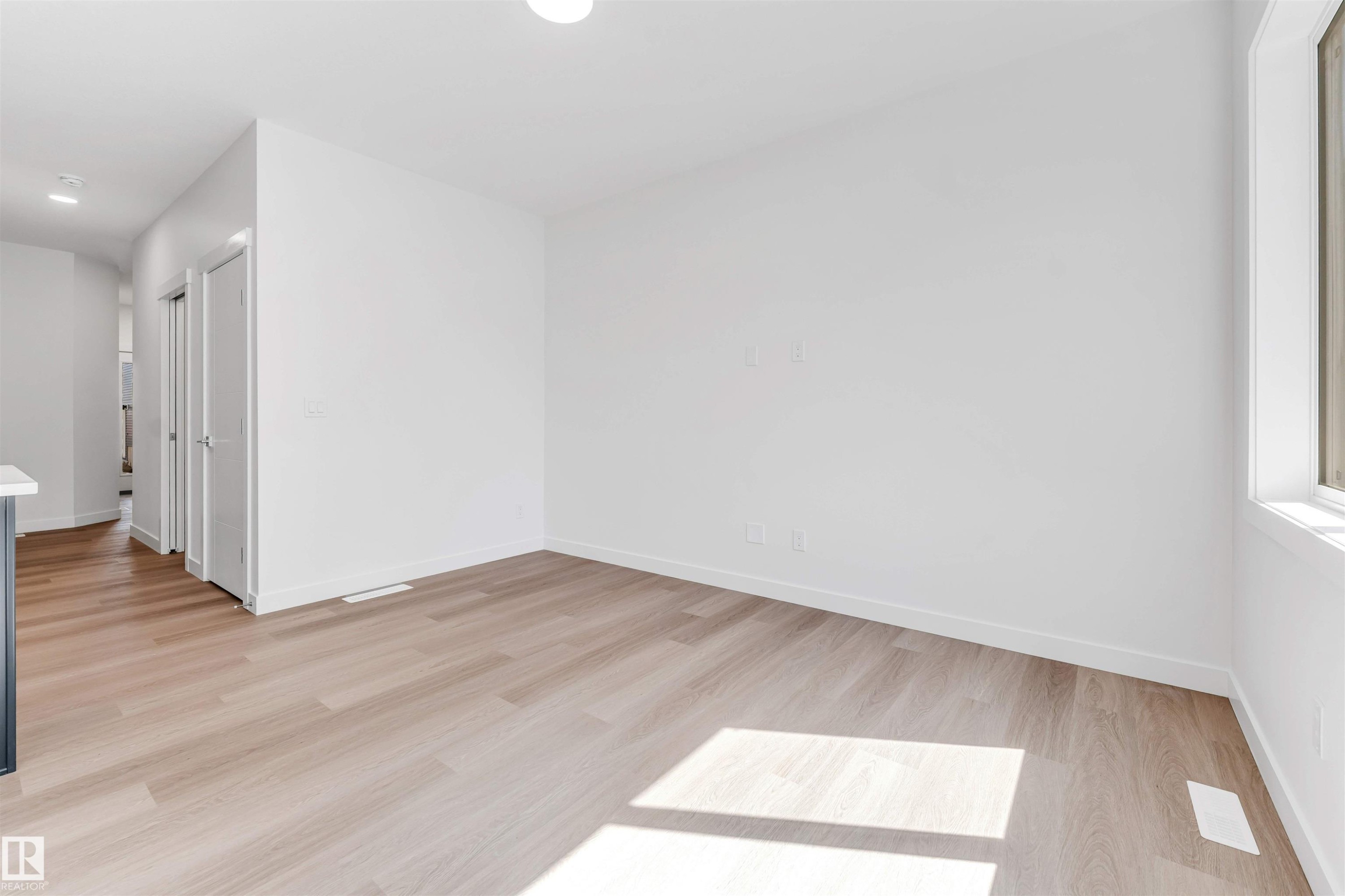 Light wood-finish flooring, white walls, recessed ceiling lighting, and a white framed window - #48 710 Mattson Dr Sw Sw, Edmonton, AB