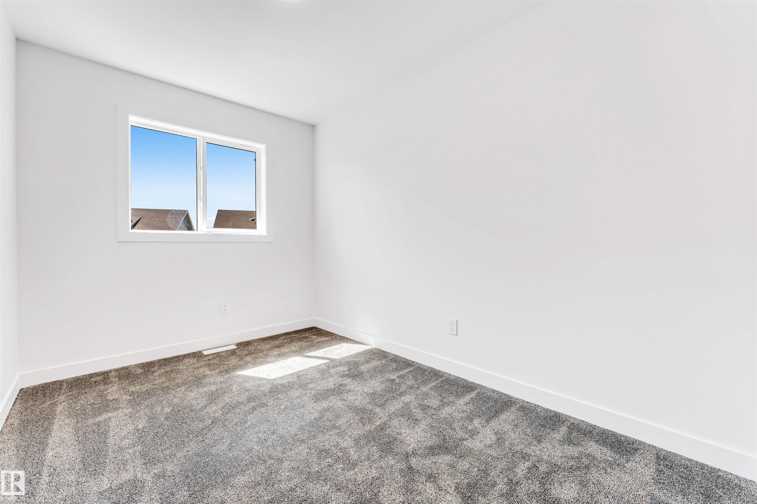 Bright corner bedroom showcasing new carpeting, clean white walls, and dual casement windows with natural light and exterior visibility - #48 710 Mattson Dr Sw Sw, Edmonton, AB