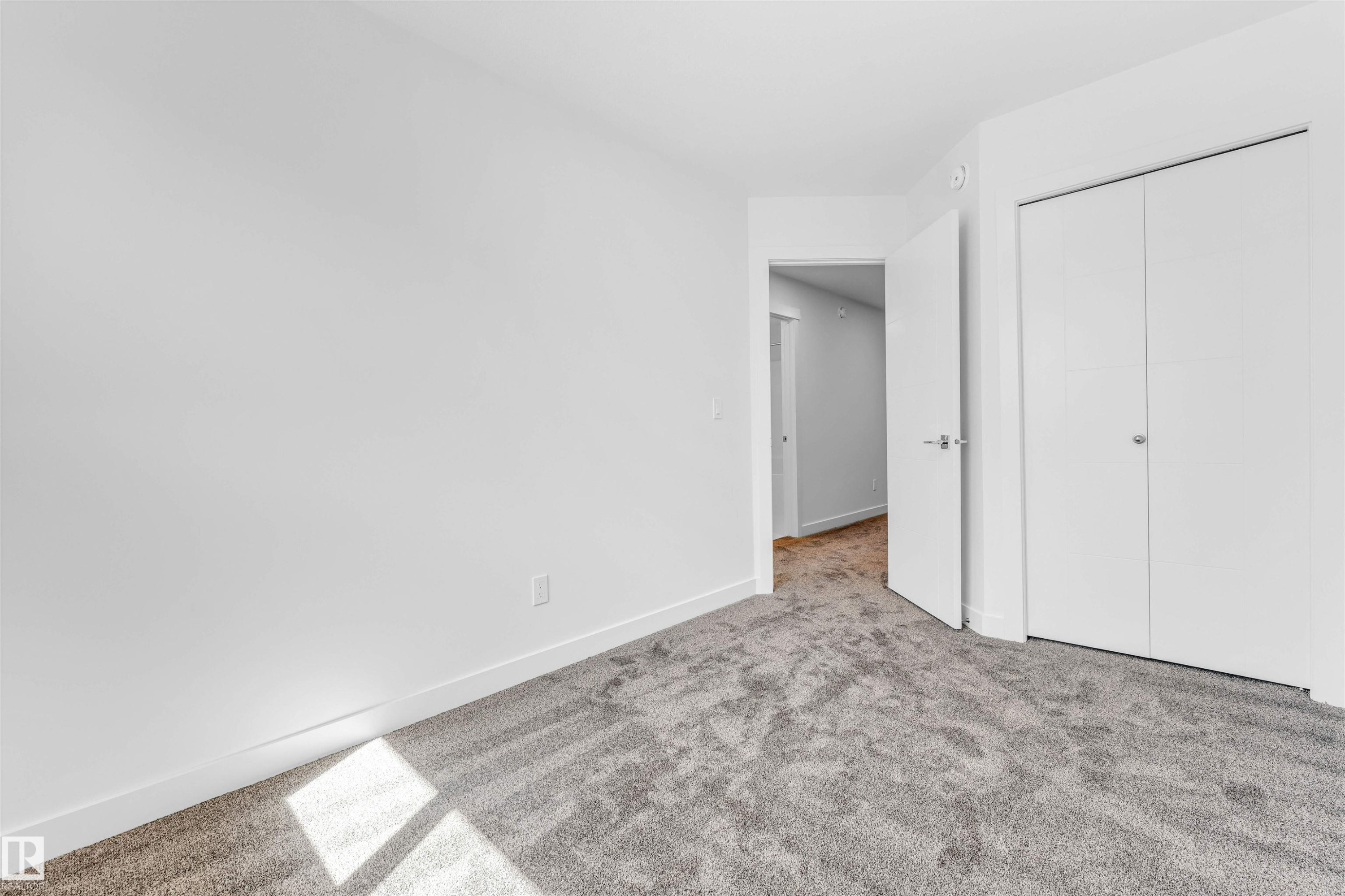 Light gray carpeting with white walls and a white bi-fold closet - #48 710 Mattson Dr Sw Sw, Edmonton, AB