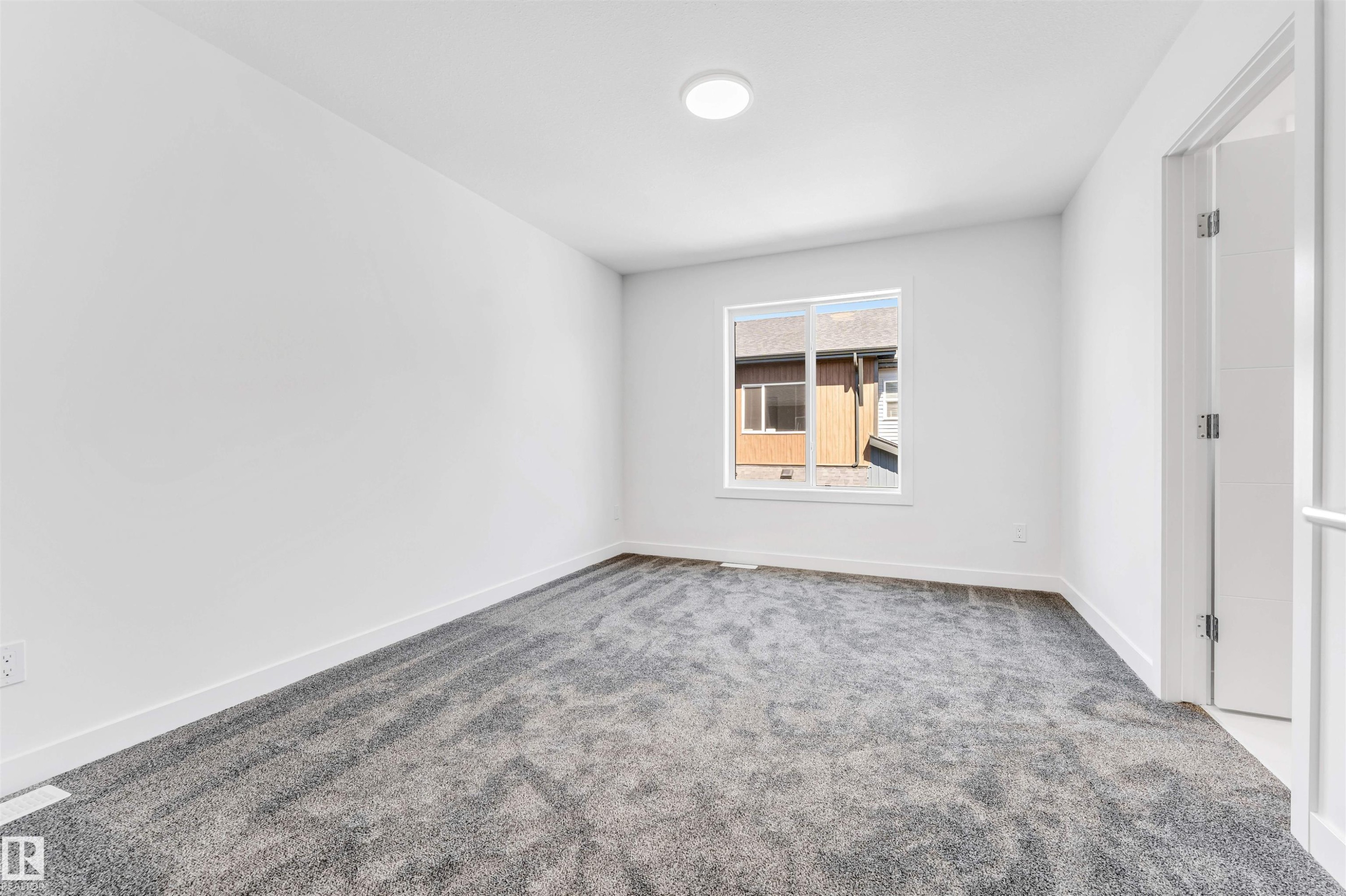 White walls, gray patterned carpet, and a window with white trim - #48 710 Mattson Dr Sw Sw, Edmonton, AB