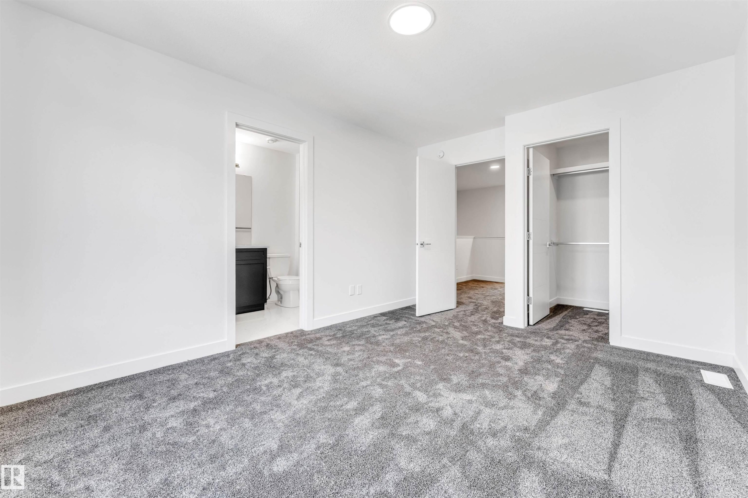 Plush grey carpeting, white interior doors, and a built-in closet with hanging rods - #48 710 Mattson Dr Sw Sw, Edmonton, AB