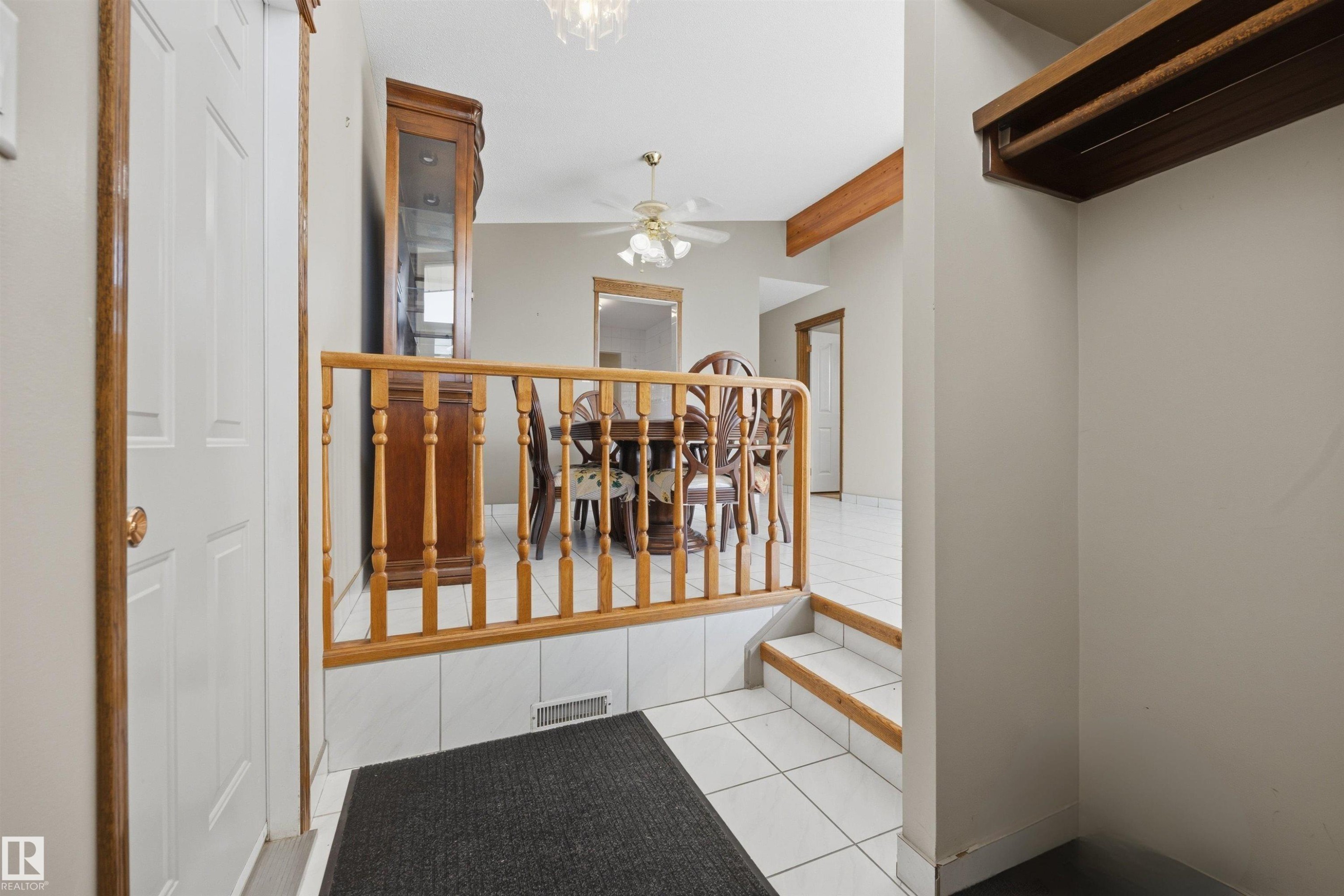 Tiled entry with wood-finish railing and steps - 14008 94 Street Nw, Edmonton, AB