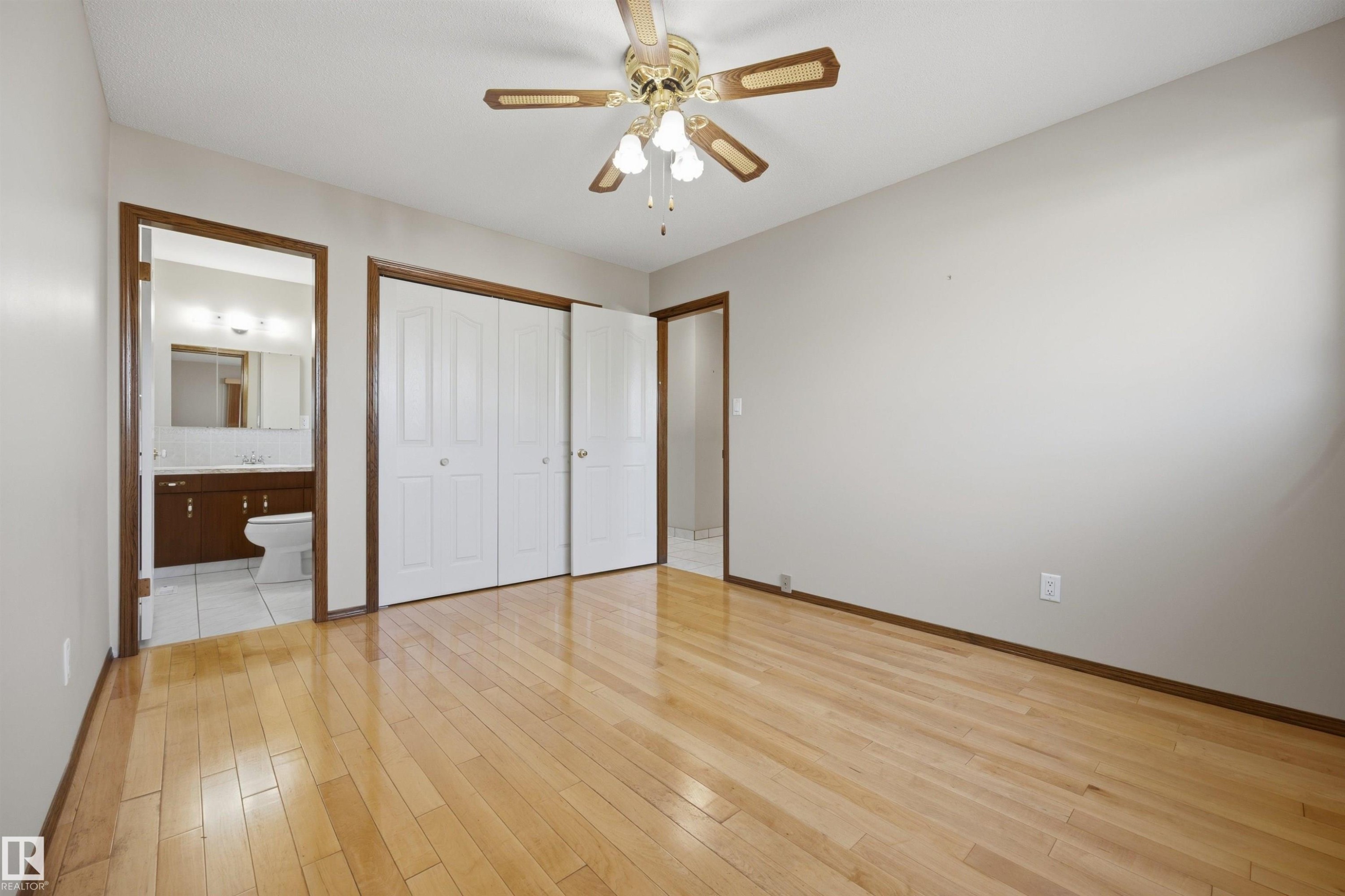 Wood-finish flooring, ceiling fan with integrated lighting, bi-fold closet doors, and recessed lighting in the bathroom - 14008 94 Street Nw, Edmonton, AB